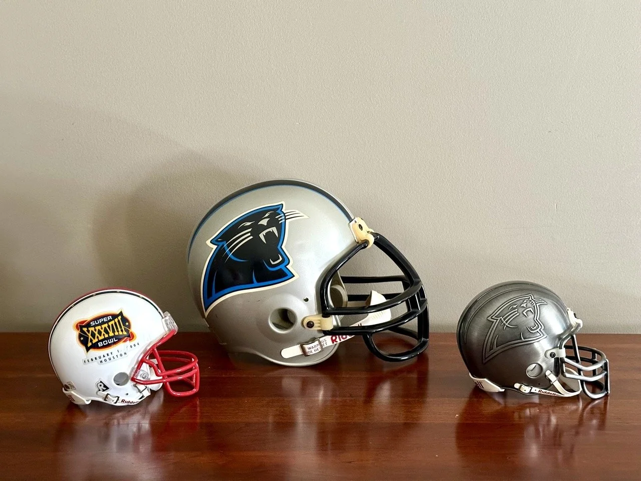 $30 • Carolina Panthers Mini Helmet Set (3) • Set of three football helmets including Carolina Panthers helmets and Super Bowl XXXVIII (Houston 2004) commemorative helmet, great for fan display or office decor, all in good condition • Dimensions: Inc