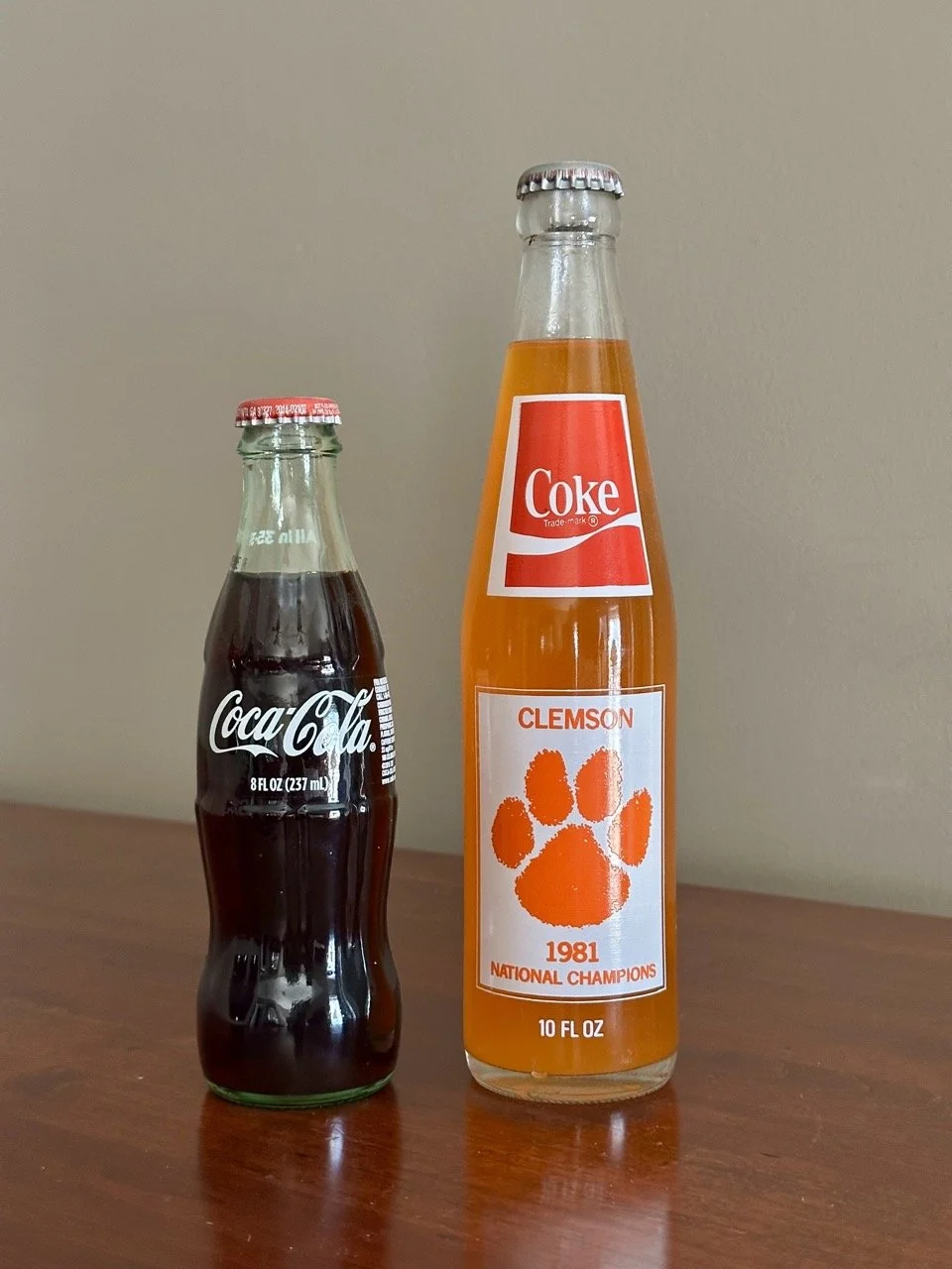 $30 • Clemson Tigers Commemorative Coca-Cola Bottle Set (1981 National Championship + Collector Bottle) • Pair of Clemson-themed glass Coca-Cola bottles including 1981 National Championship season bottle with game schedule and commemorative Coke bott