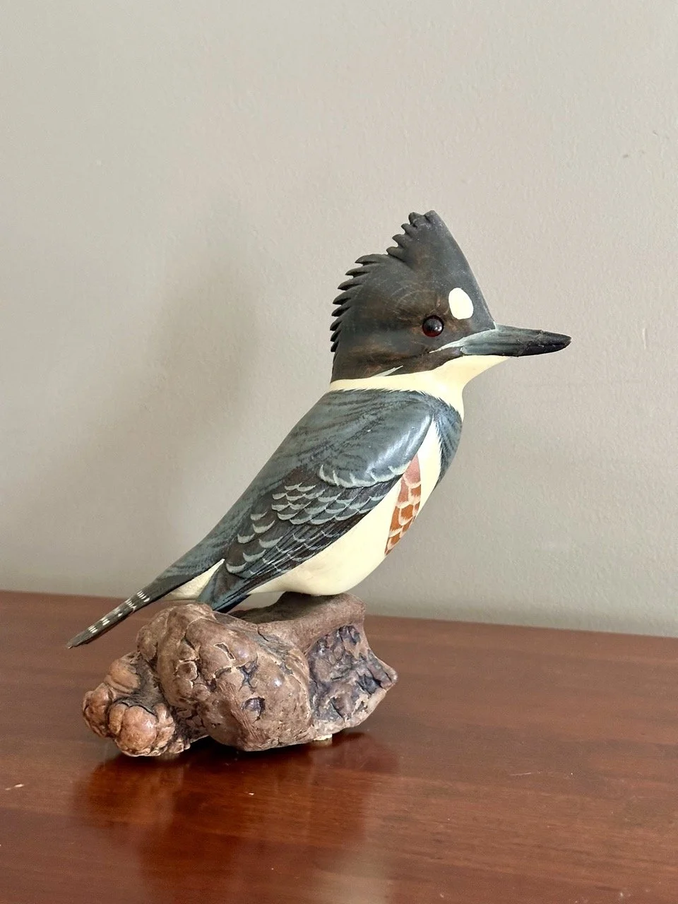 $80 • Hand-Carved Kingfisher Bird Sculpture on Burl Wood Base • Beautifully detailed carved and hand-painted bird perched on naturalistic base, with visible wood grain integrated into the design, high-quality folk art piece • Dimensions: 9.25” H x 7.