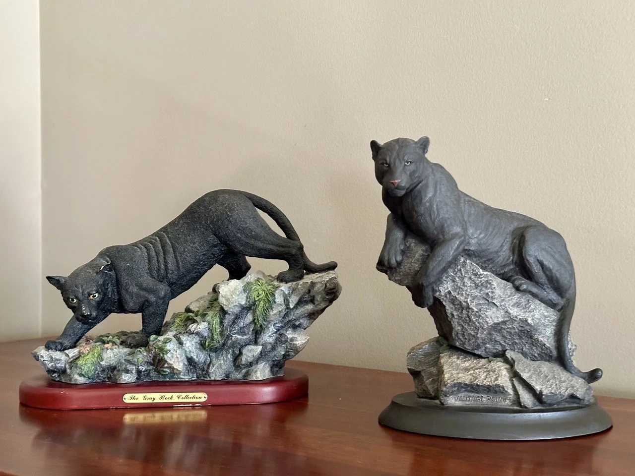 $45 • Pair of Panther Figurines on Bases • Two detailed black panther sculptures with textured bases (one wood-tone, one dark base), great for shelf or desk decor, in good used condition with light wear • Dimensions: Wood base figure 10.5” L x 8.5” H