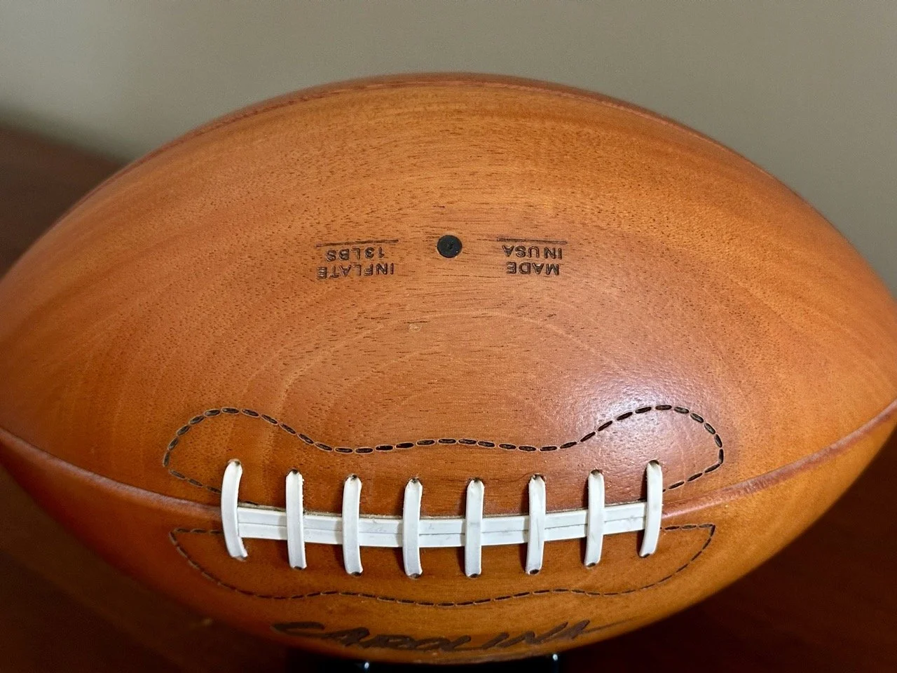 $45 • Carolina Panthers Carved Wooden Football Display with Stand • Realistic carved wood football featuring engraved Panthers logo and lettering with detailed stitching and valve detail, official NFL licensed piece made in USA, great for office or f