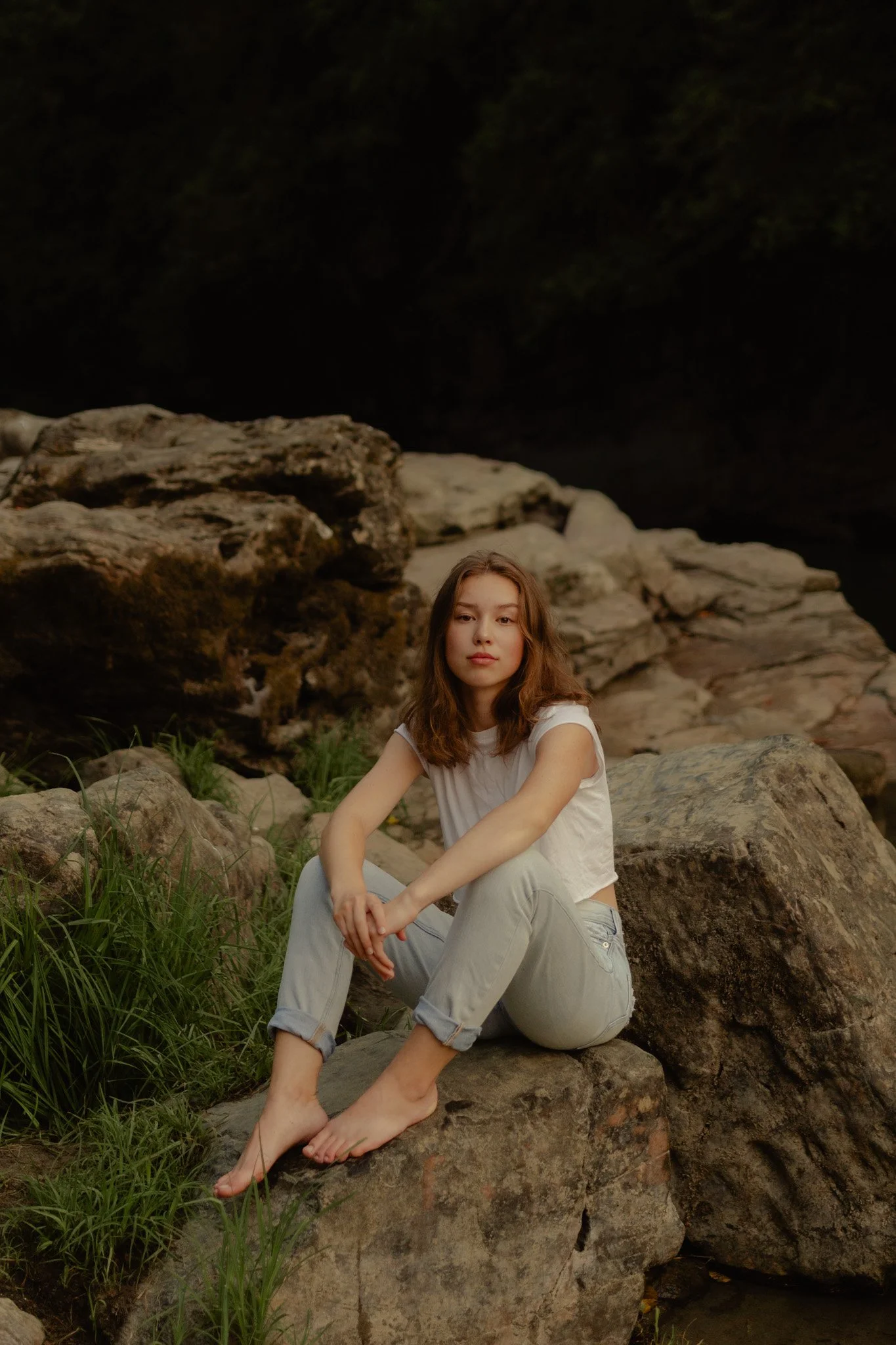 Senior posing on rocks by waterfall at eagle falls in snohomish county, Washington.