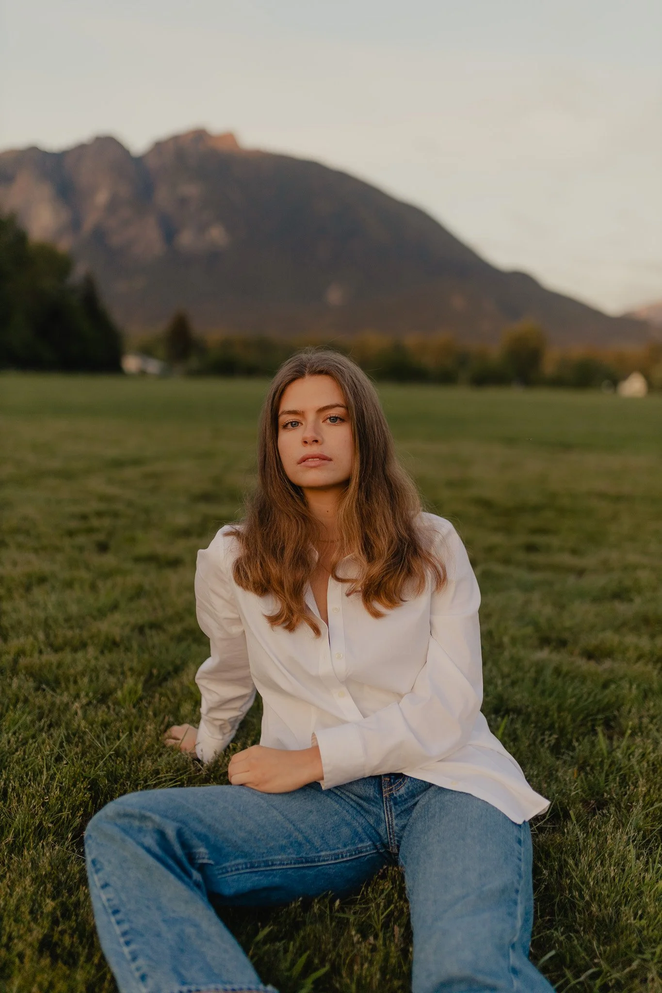 Senior posing for her senior portrait in a field in North Bend, Washington.