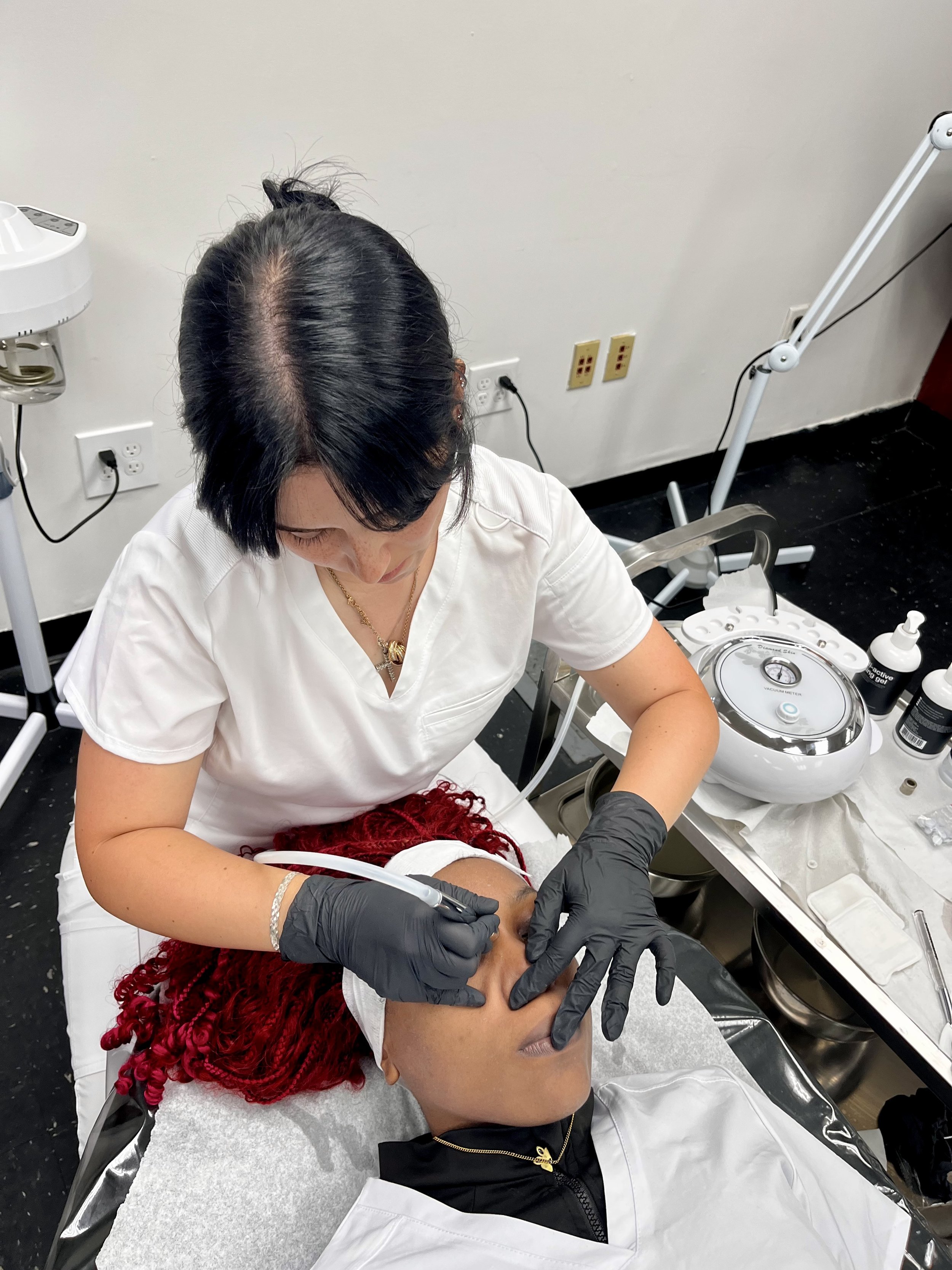 Performing microdermabrasion to gently exfoliate and smooth the skin’s surface.