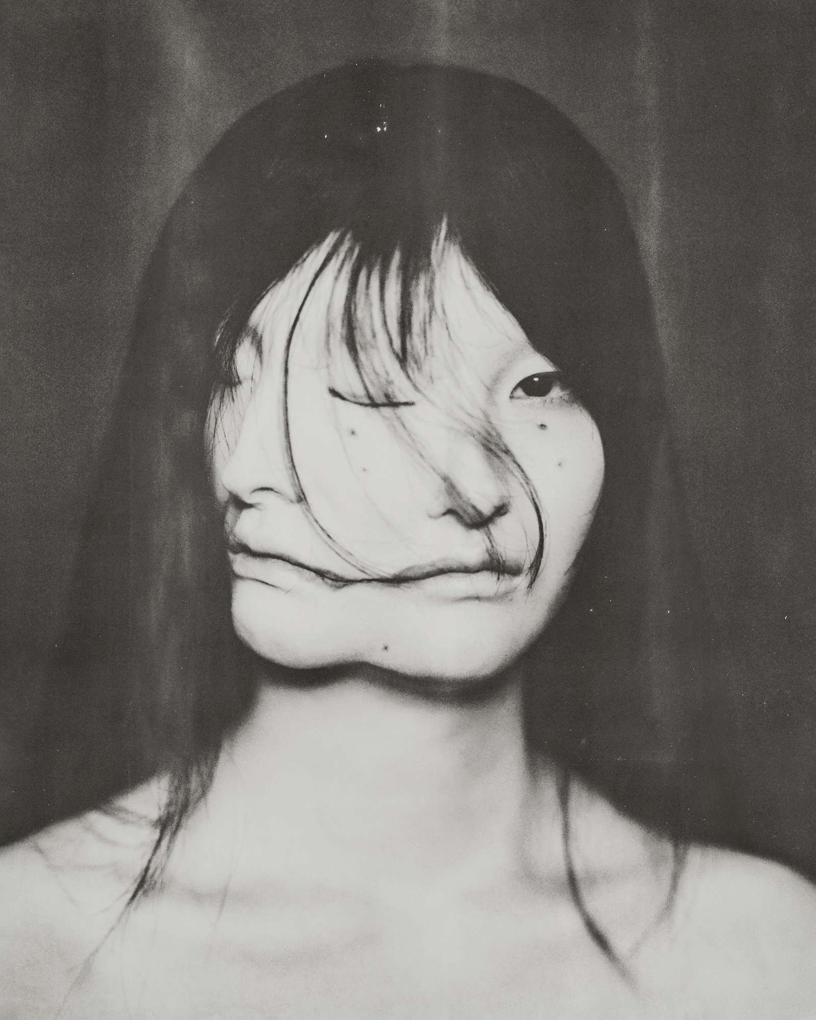Miku by Yuji Watanabe: portrait of a woman whose face seems to fold into two, long dark hair falling across it