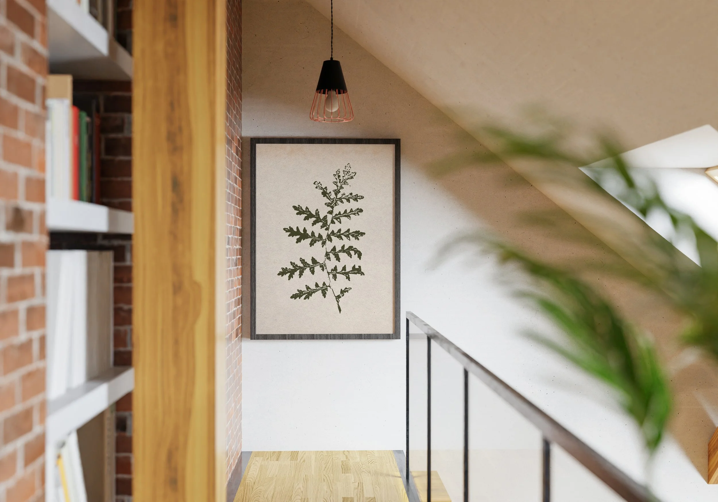 Interior view of a staircase landing with a framed botanical print on a white wall, a hanging black and copper pendant light, a brick wall on the left, a bookshelf, and part of a houseplant on the right.