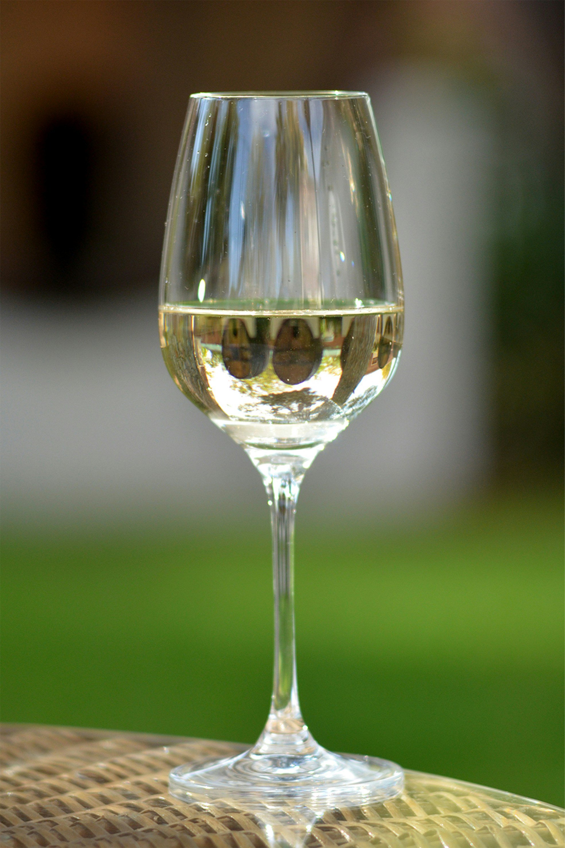 Glass of chilled white wine reflecting the surroundings.