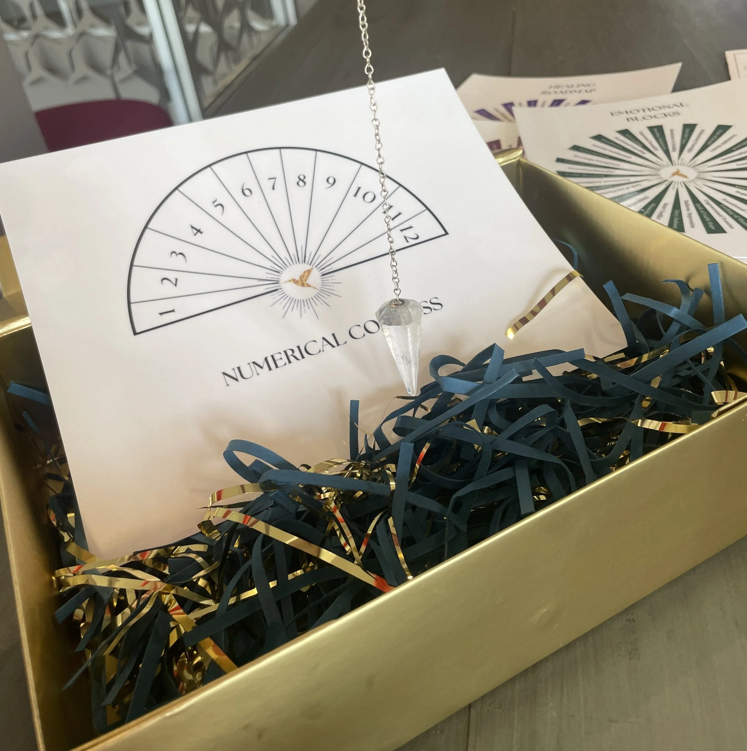 Pendulum and numerical compass chart in a gift box, tools from practitioner training for working with contact experiencers