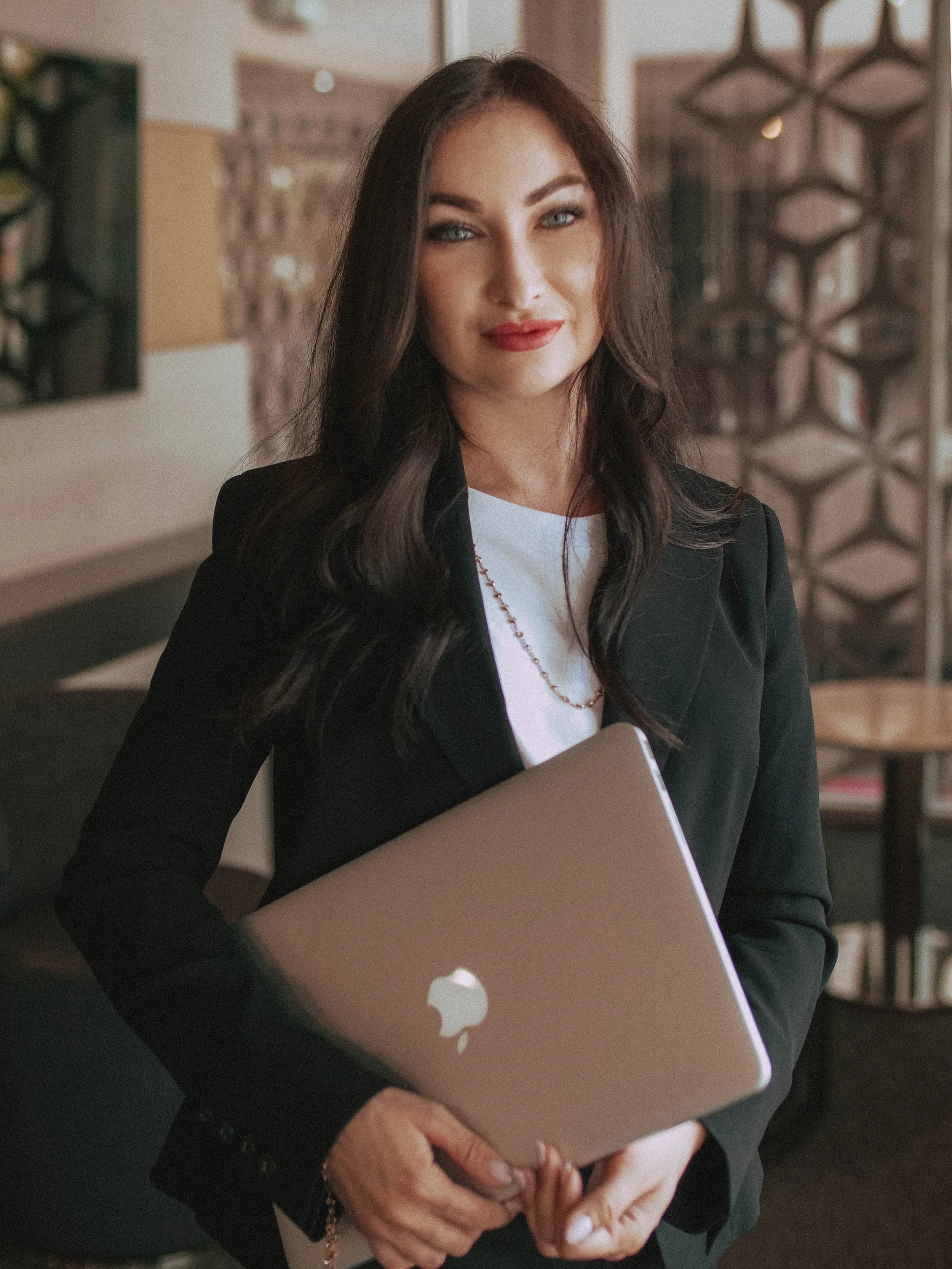 Elina, alien abduction regression specialist offering contactee support, holding a laptop in Los Angeles