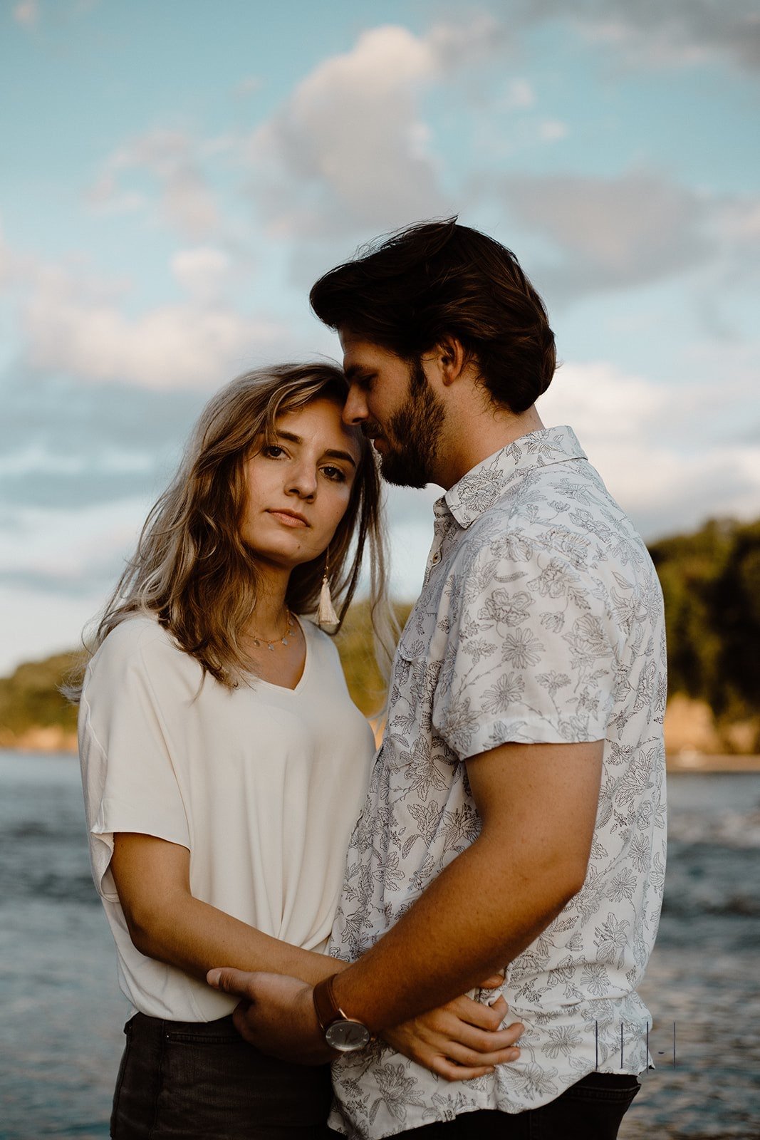 waterfront with a couple embracing against summer evening sky