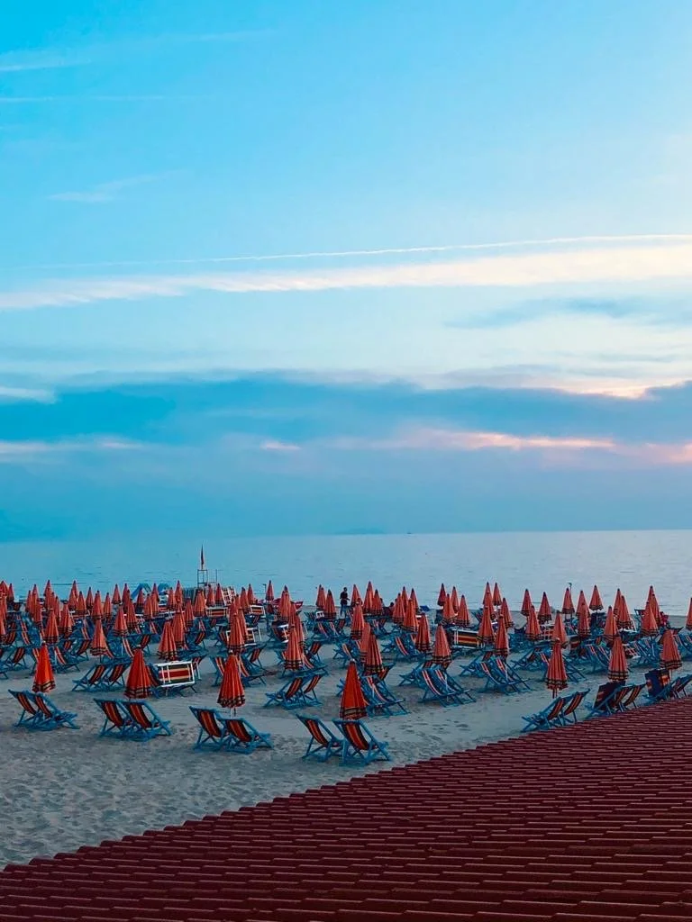 vivid colors of blue sky against deep red umbrellas beachside
