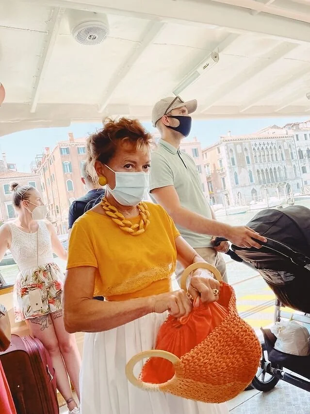 an elegant and sophisticated woman in bright colors casting a glance of intensity
