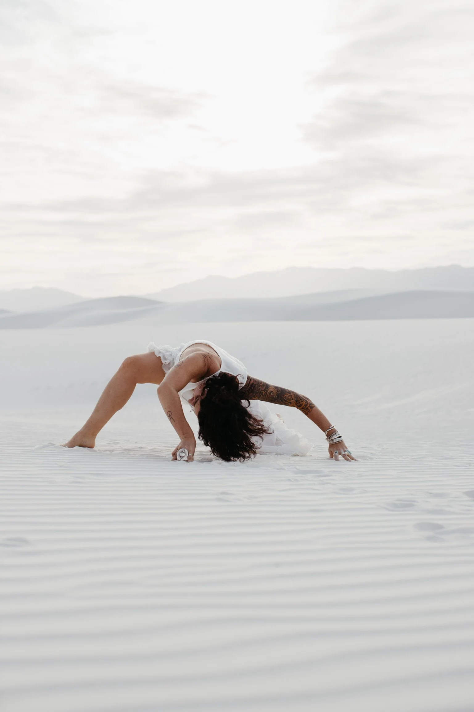 Person sharing expressive movements on white sand dunes