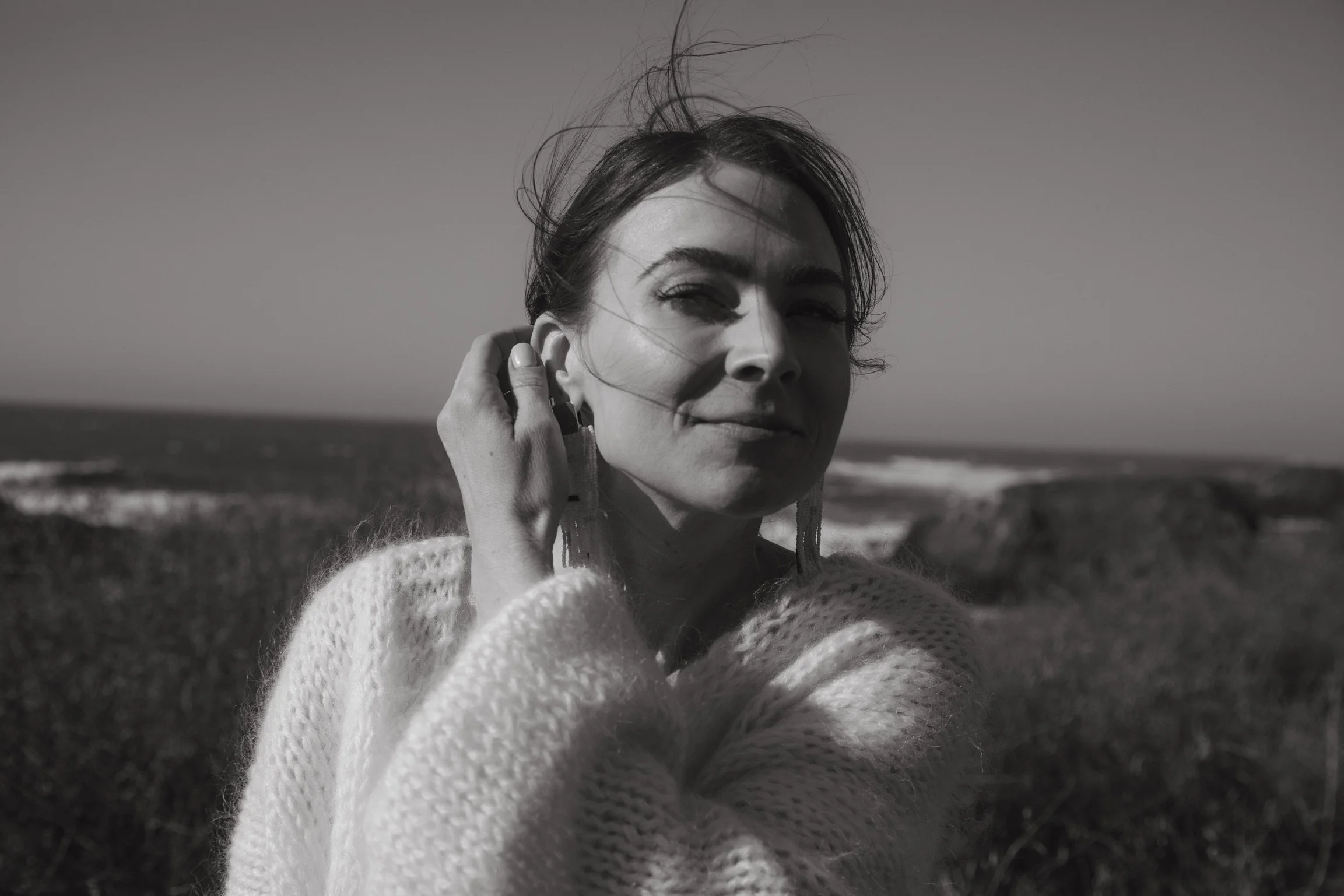 oceanside with waves crashing in the background with a fashionable bride windswept