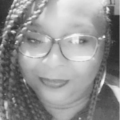 Black and white photo of a person wearing glasses with braided hair