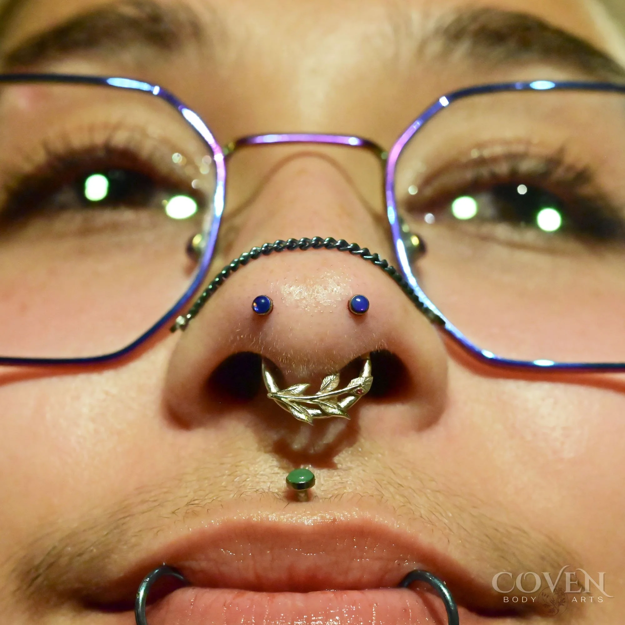 mantis piercings on a person with a septum piercing, philtrum or medusa piercing and a double lip piercing performed with a mixture of implant grade titanium and 14k gold body jewelry. Nostril piercings called mantis piercings that were done by Dee a