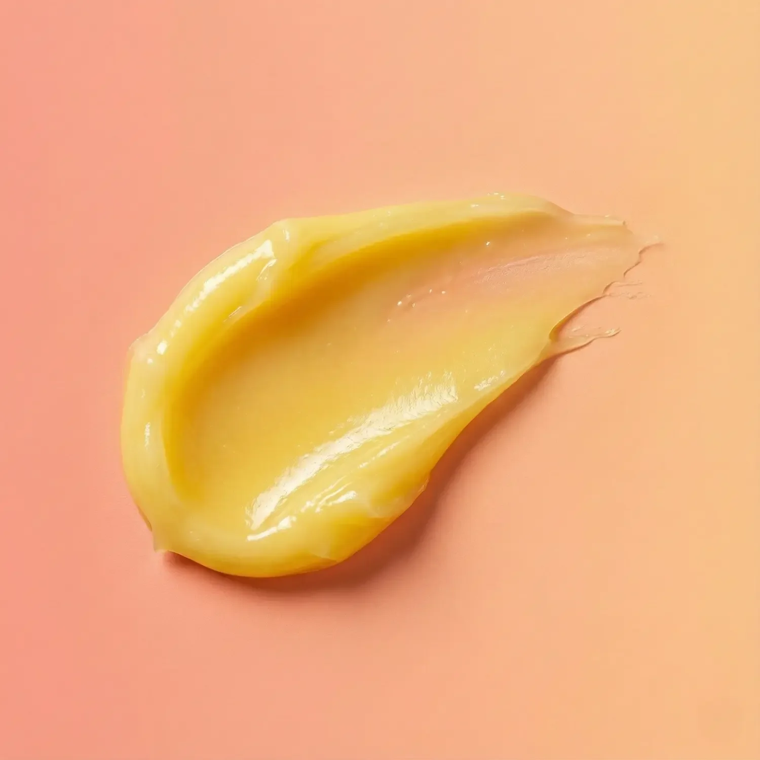 mango-lip-balm-smear-on-peach-background.webp