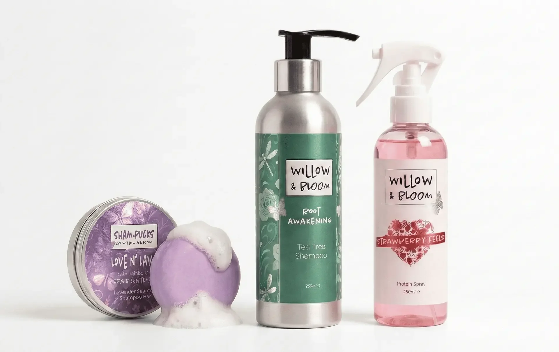 Hair care and styling products, including a pink protein spray, a green tea tree shampoo, a purple shampoo bar, and a purple bath bomb.
