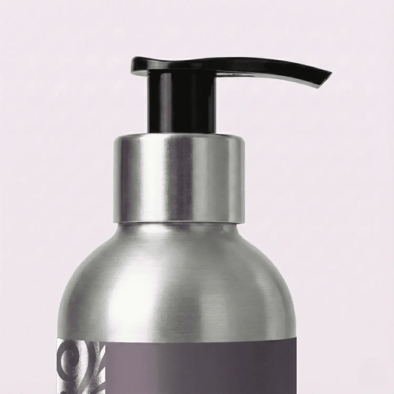 Close-up of a aluminum dispenser pump on a black bottle.