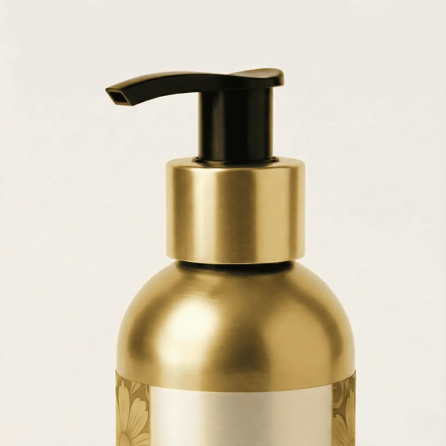 Close-up of a gold pump dispenser on a bottle with a white label and floral design.