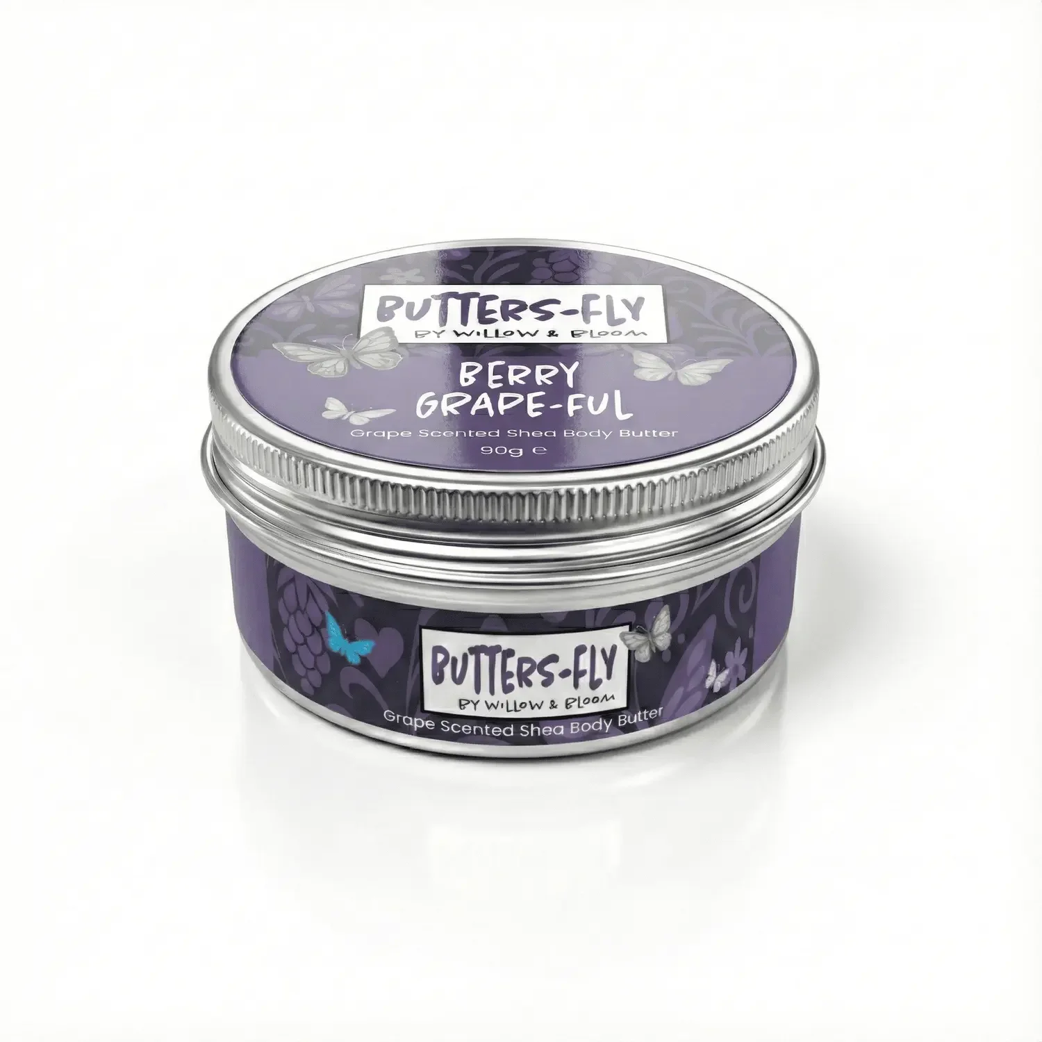 A round container of Butters-Fly Shea Body Butter with a purple label, featuring illustrations of butterflies and grapes, labeled 'Berry Grape-full' with a silver lid.