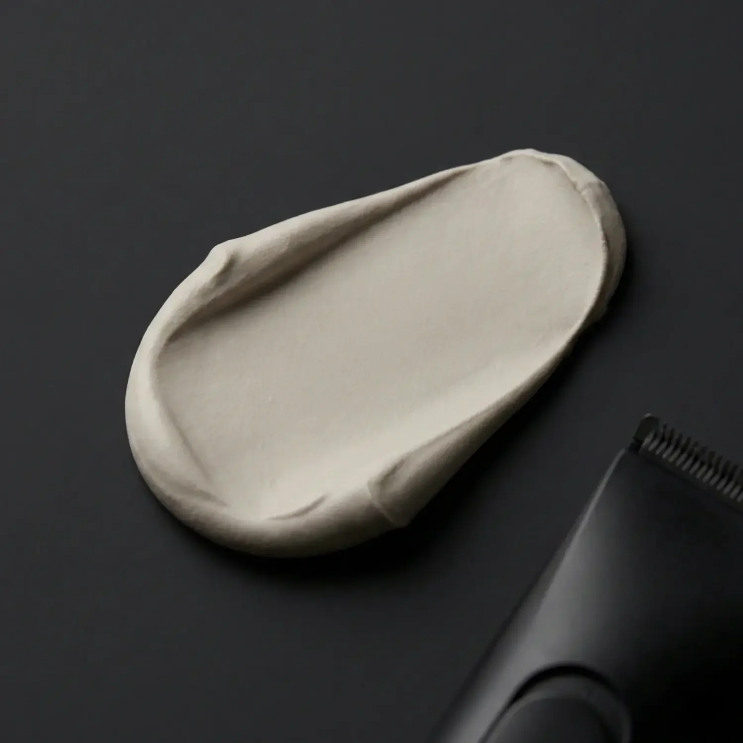 smudge-of-thick-hair-paste-on-dark-grey-background.webp