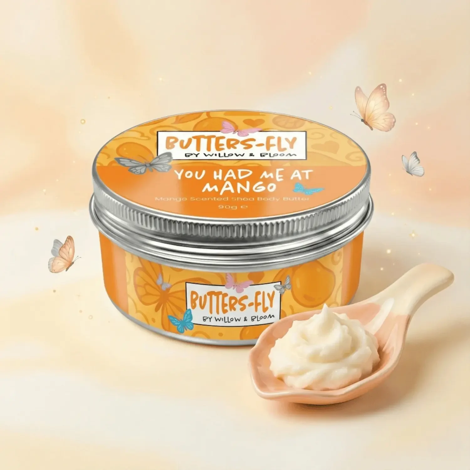 A jar of Butter-Fly body butter flavored like mango, with a spoonful of the butter in a pink bowl beside it, surrounded by fluttering butterflies.