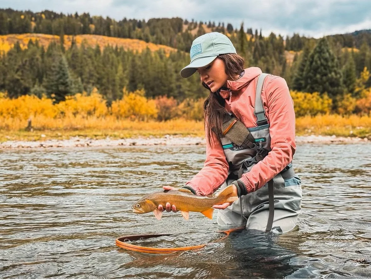 RockSpring Nets' wooden landing net beside an angler releasing a cutthroat trout in a mountain stream, showing lightweight design and control