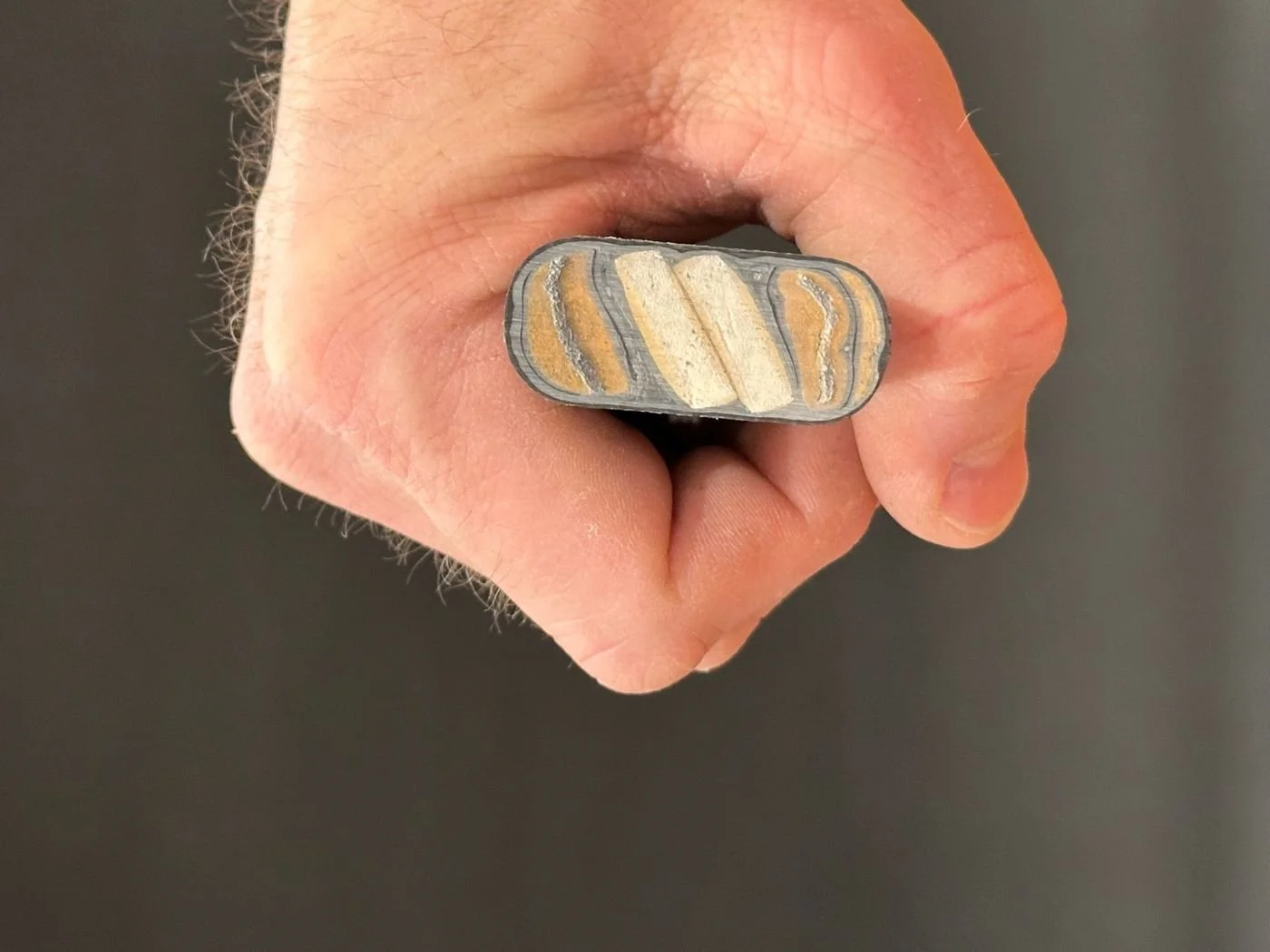 Cross-section of a competitor's net handle showing visible gaps between the handle and an angler's hand grip, highlighting poor ergonomics and reduced control compared to RockSpring Nets.