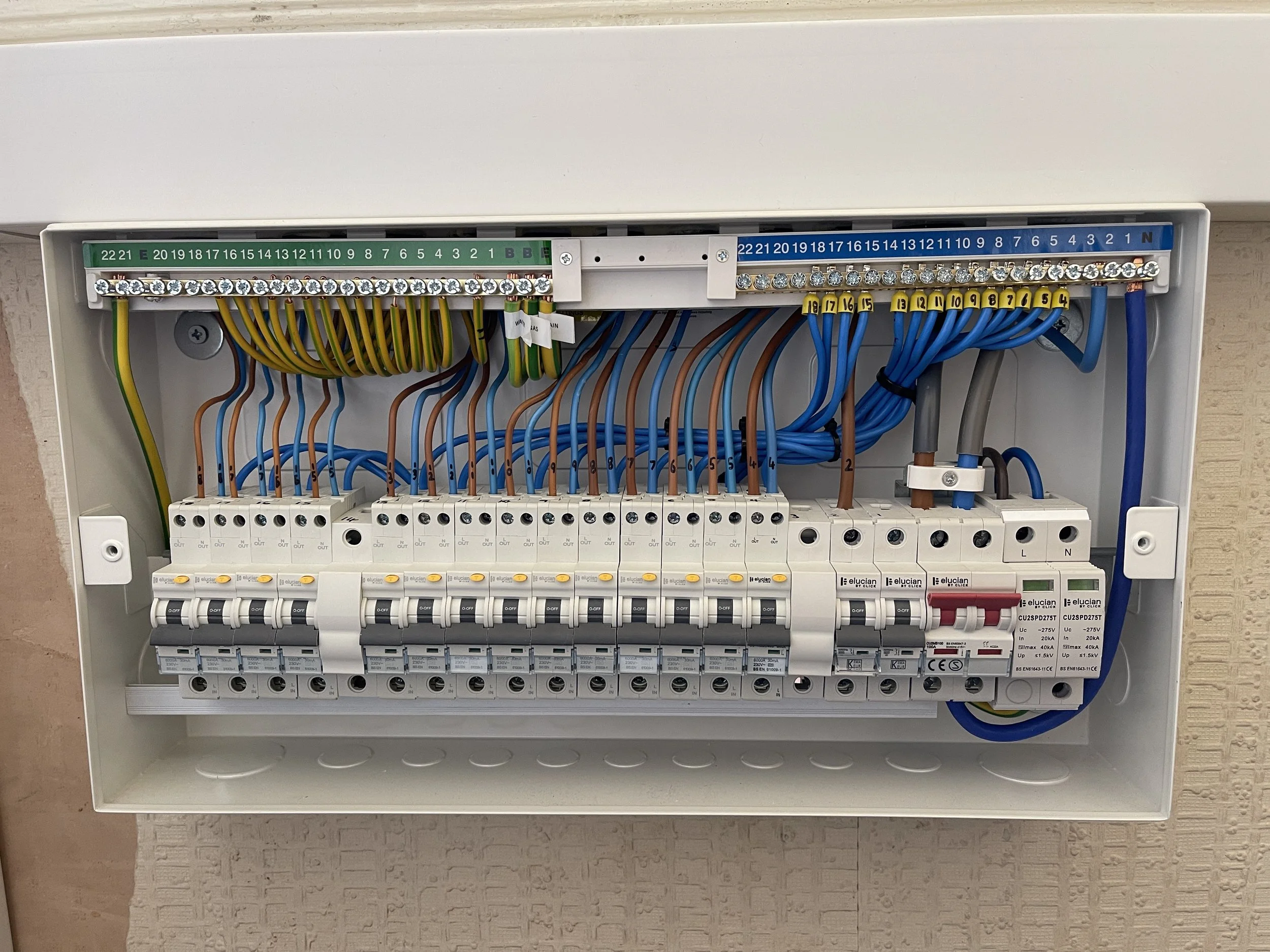 An electrical breaker panel with multiple wires connected to circuit breakers and terminal strips.