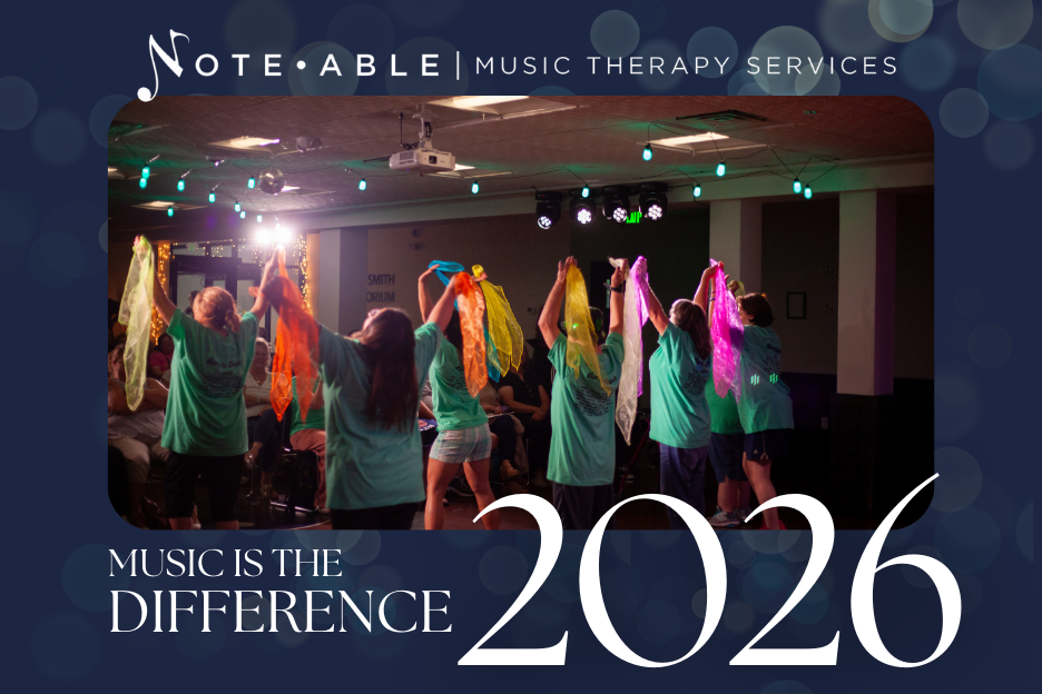 Group of children performing a dance with colorful scarves on stage during a music therapy session at Note Able Music Therapy Services in 2026.