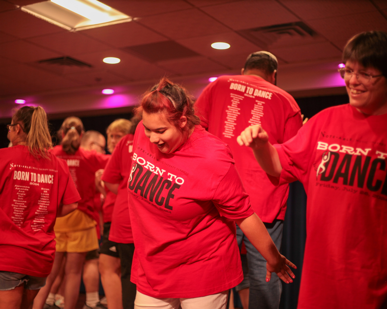 NMTS dance participants wearing matching red Born to Dance shirts during a group performance.