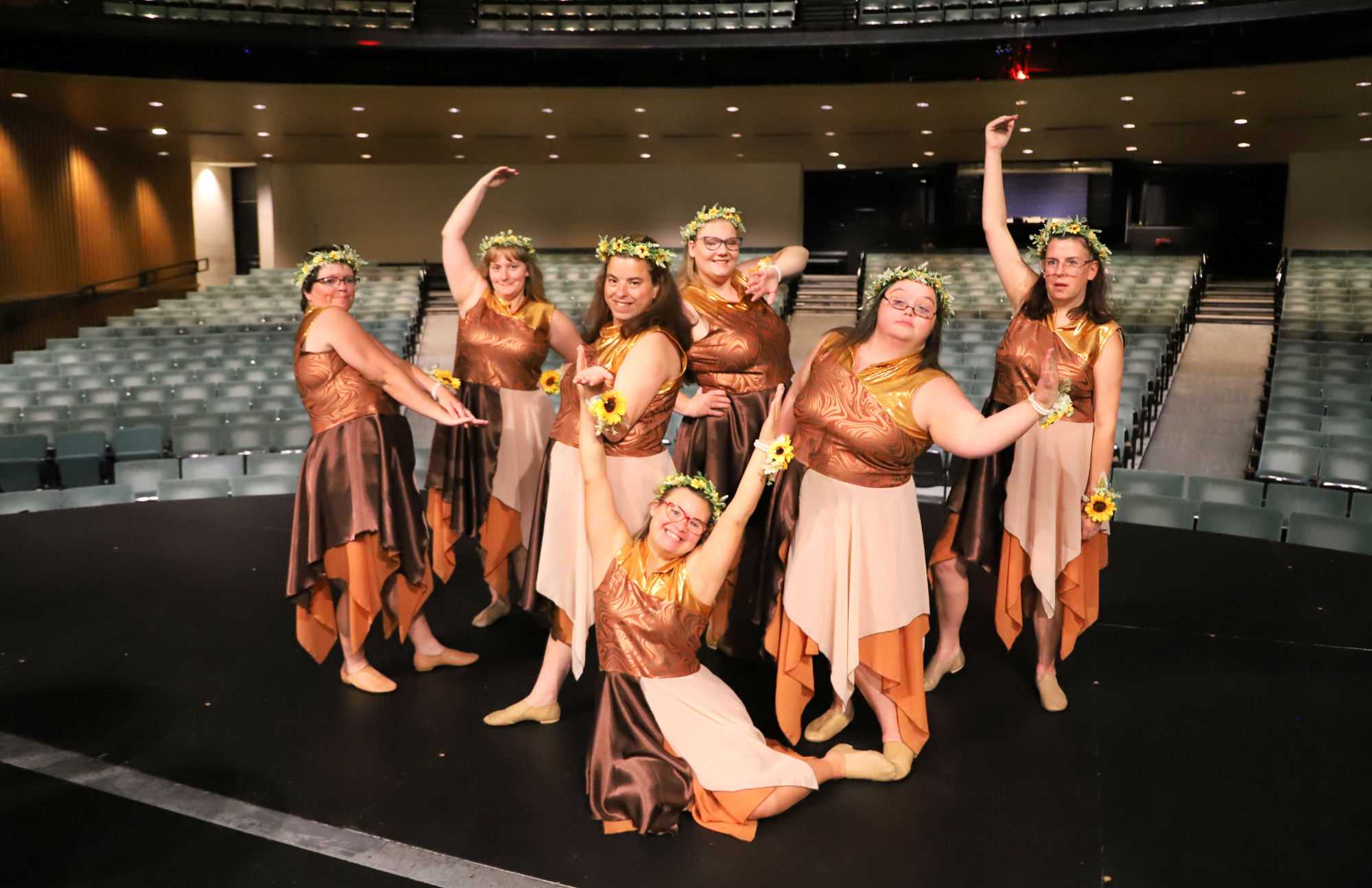 The dancers backstage in thier earth tone costumes and flower headpieces