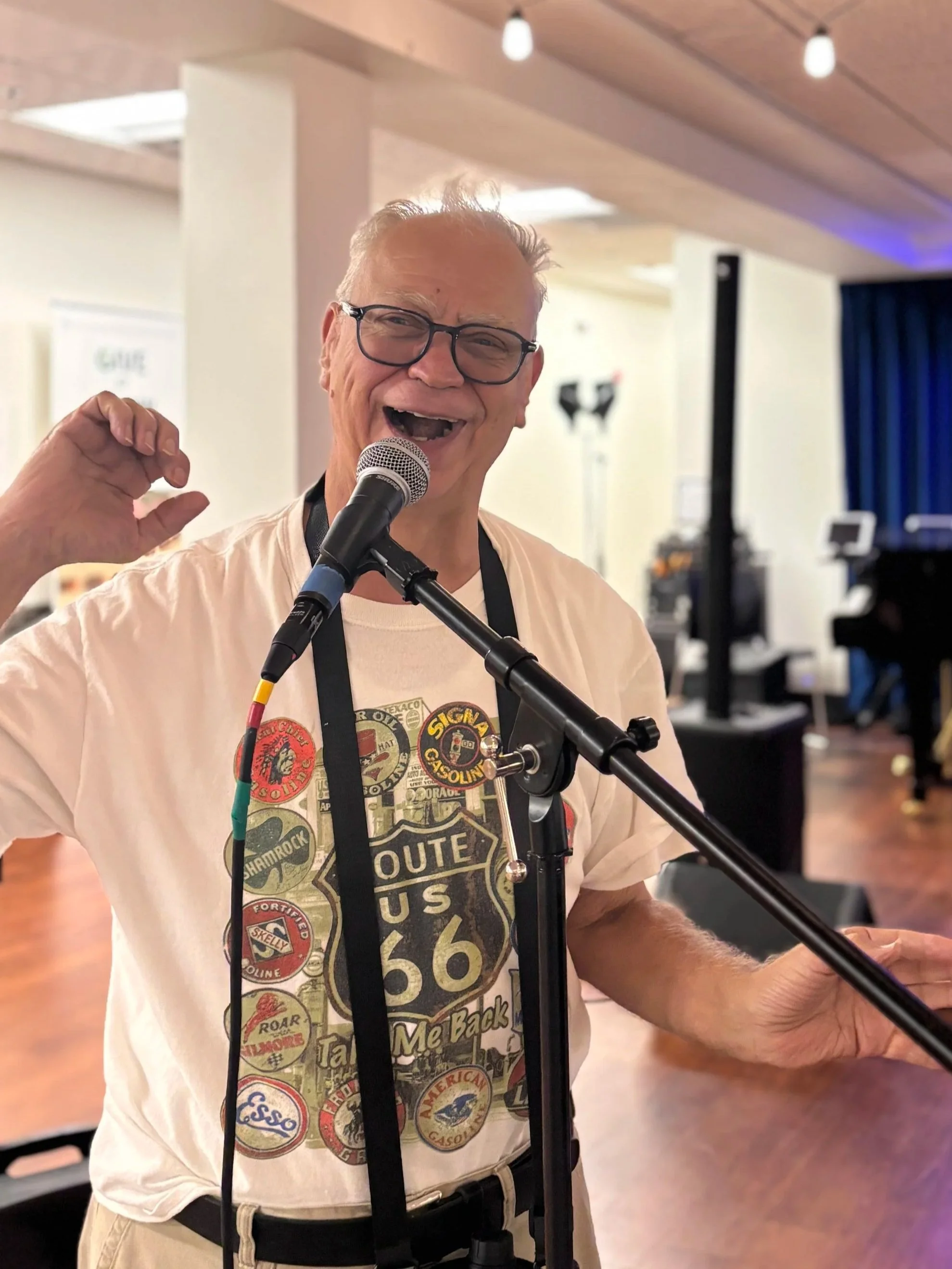 Older man singing into microphone at the 2025 NMTS teen and adult summer music camp