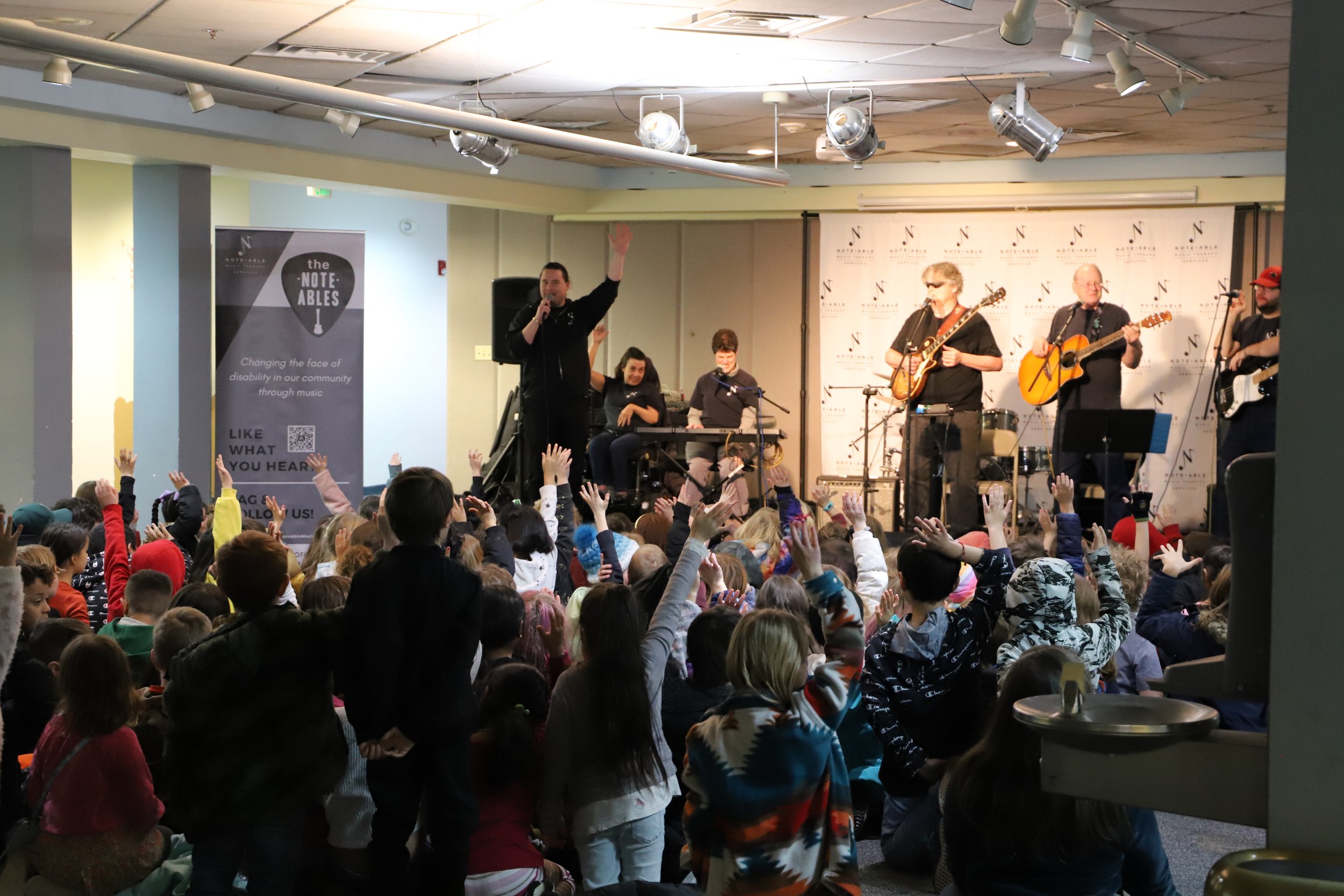 The Note-Ables band receiving questions from a group of children.