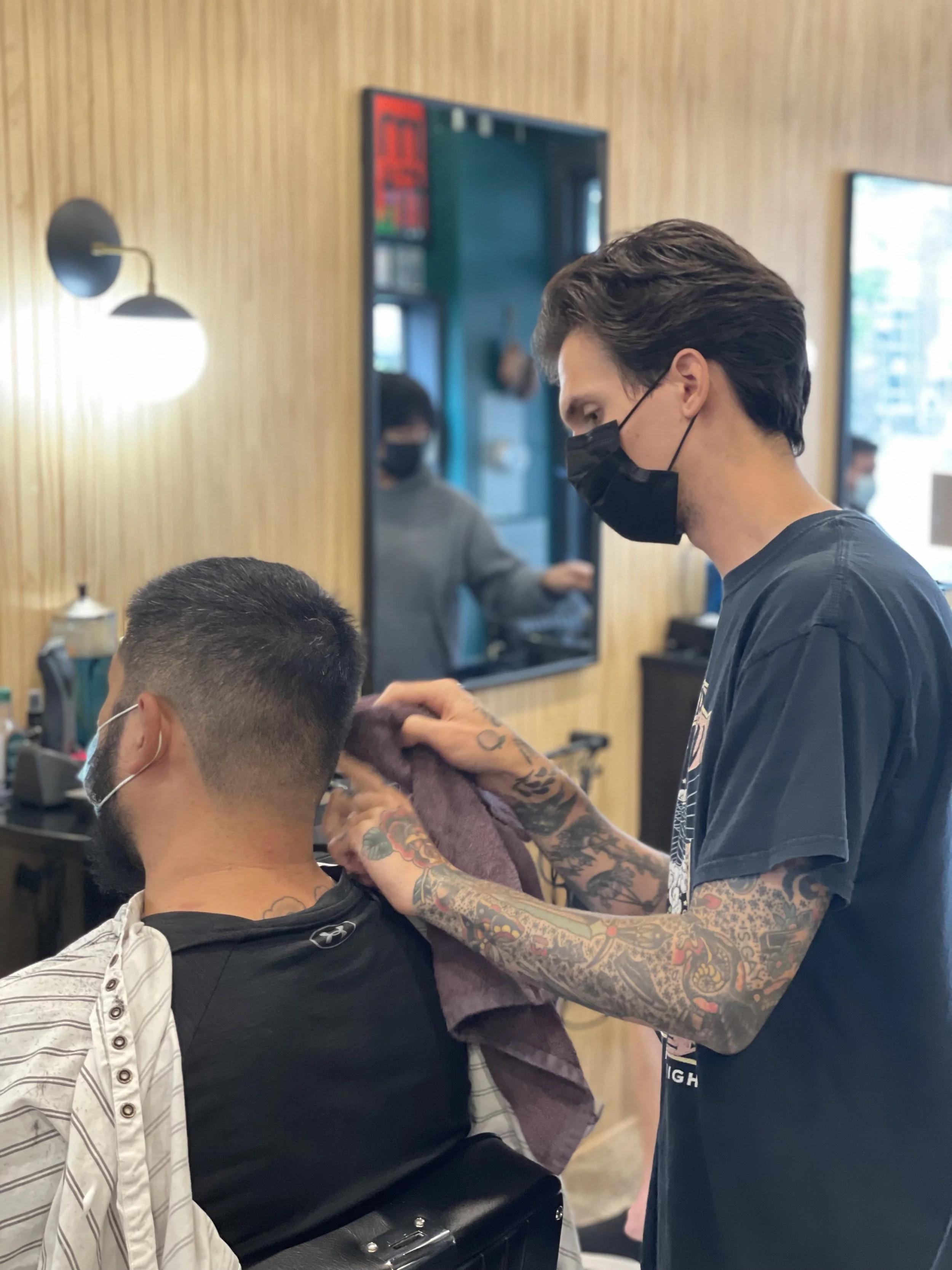 A barber giving a haircut inside Georgie’s Barber in Takoma Park.
