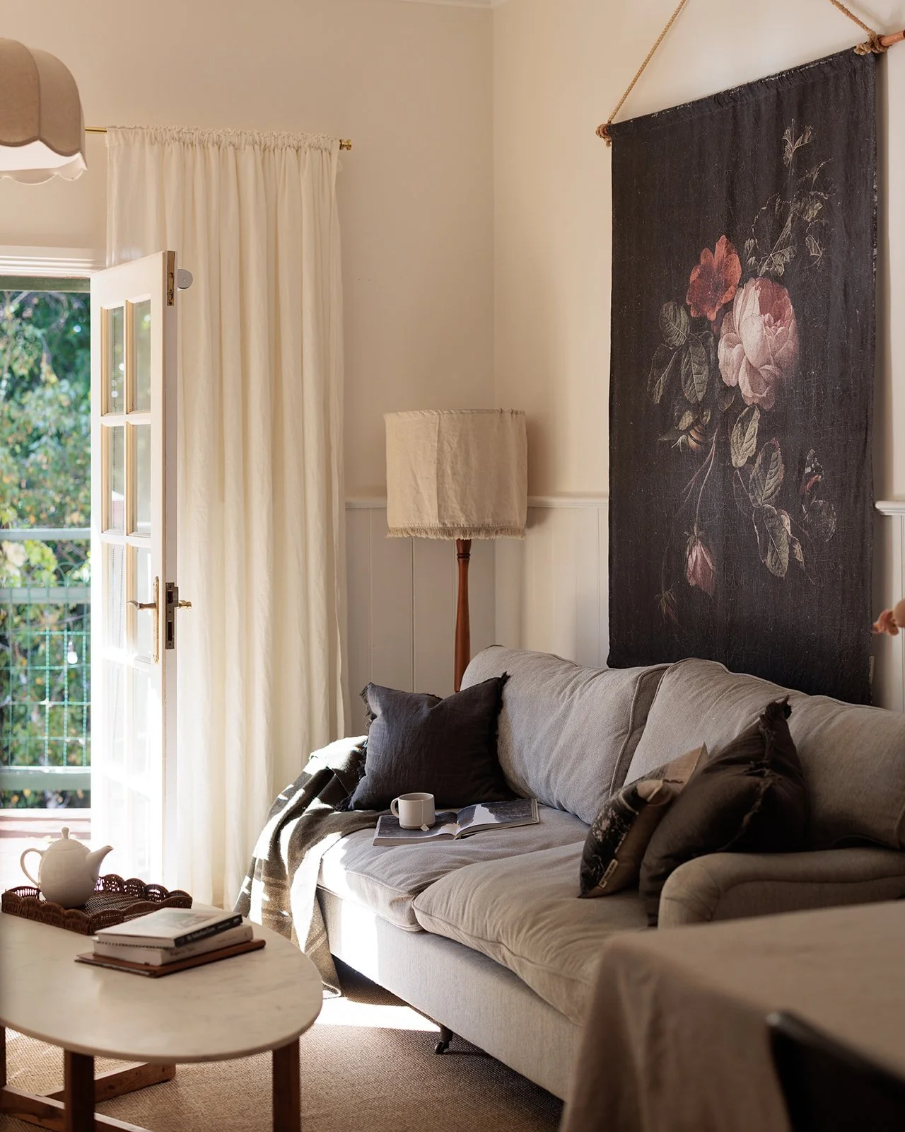 Kelly House loungeroom.  Decorated with a sofa and a beautiful rose wall hanging.  