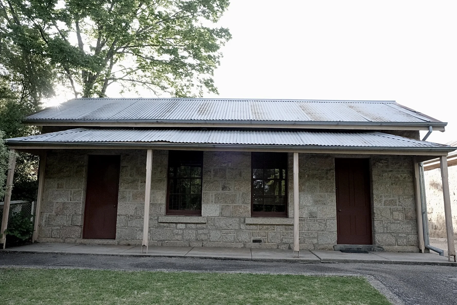 Historic Building of Beechworth.  Stone building with tin roof and tree behind.