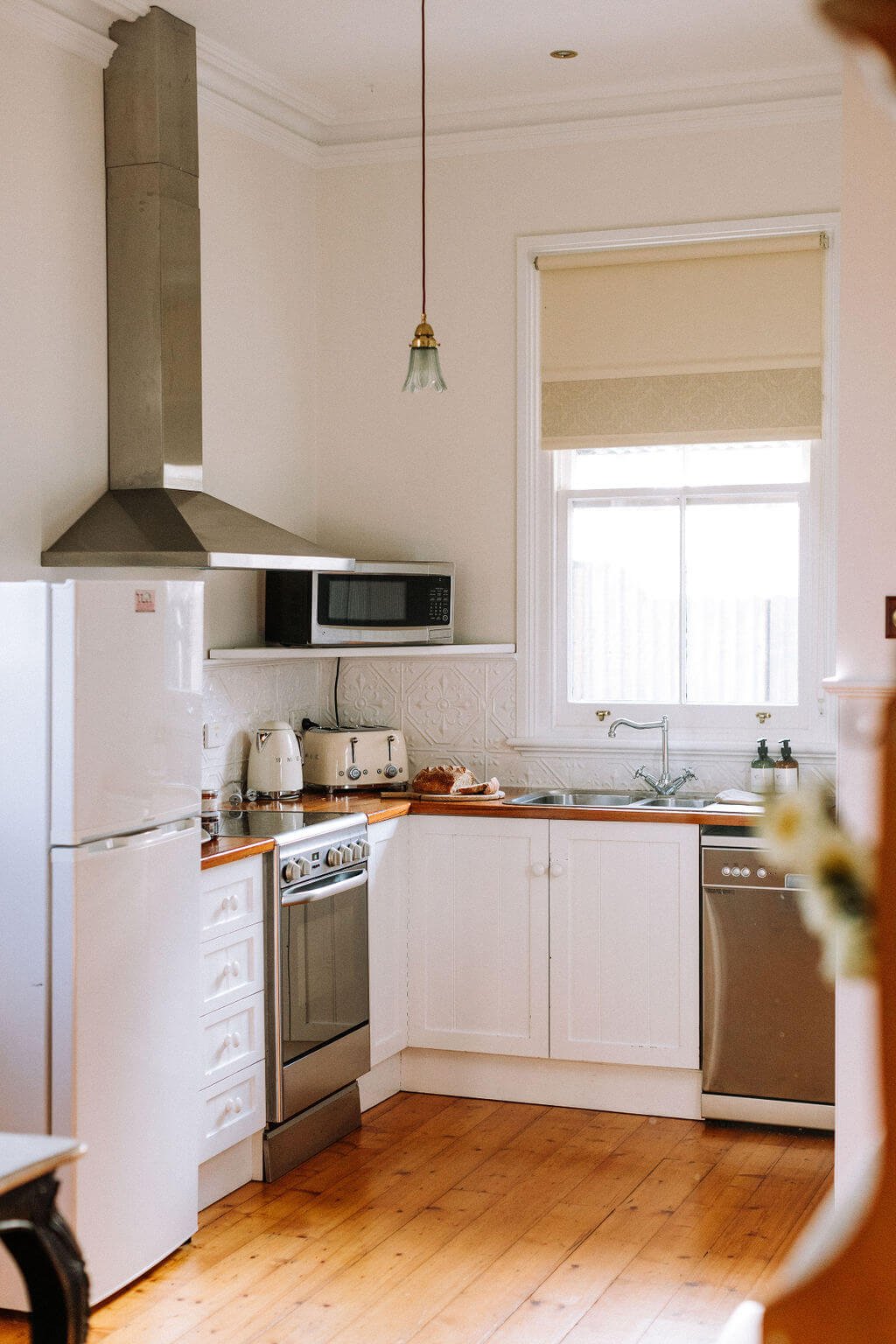The Inn Beechworth, Luxury Accommodation - Kelly House. A kitchen with white cabinets, a stainless steel stove, refrigerator, and dishwasher.
