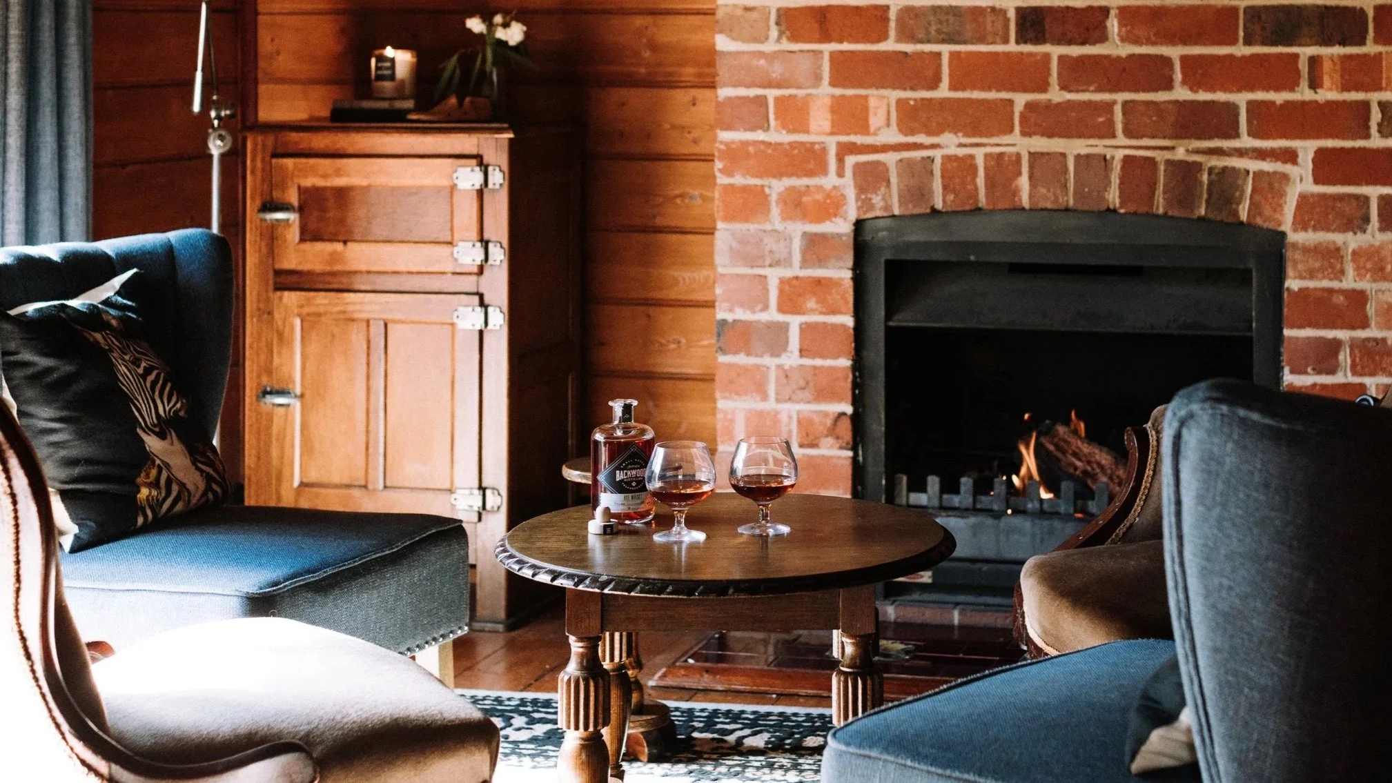 A bottle of Backwoods Whiskey and a table in the whiskey room at The Inn Beechworth