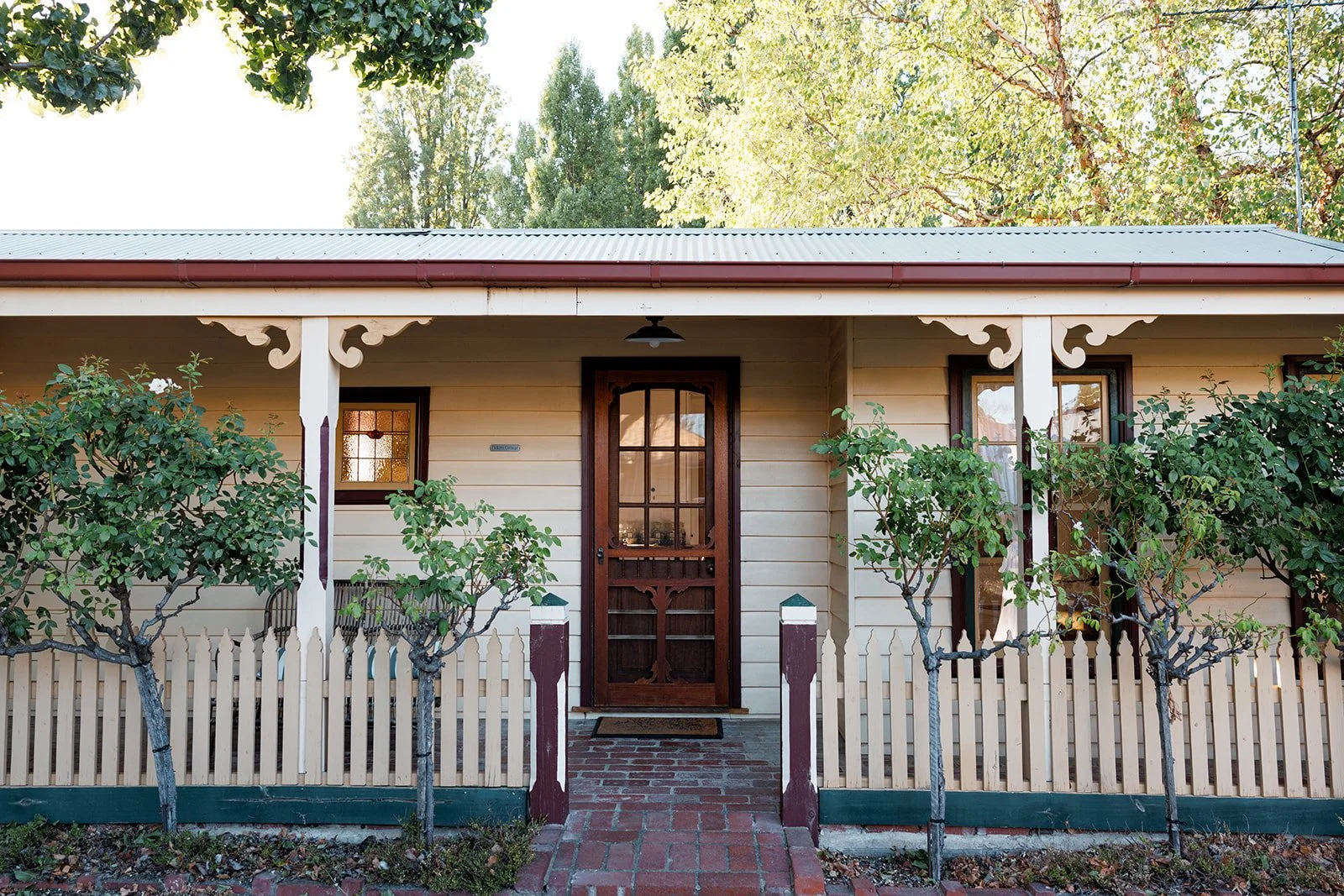 Picketts Cottage bedroom is made for snuggling. A neatly made bed with white bedding and a patterned black and white pillow, in a bedroom with a black headboard.