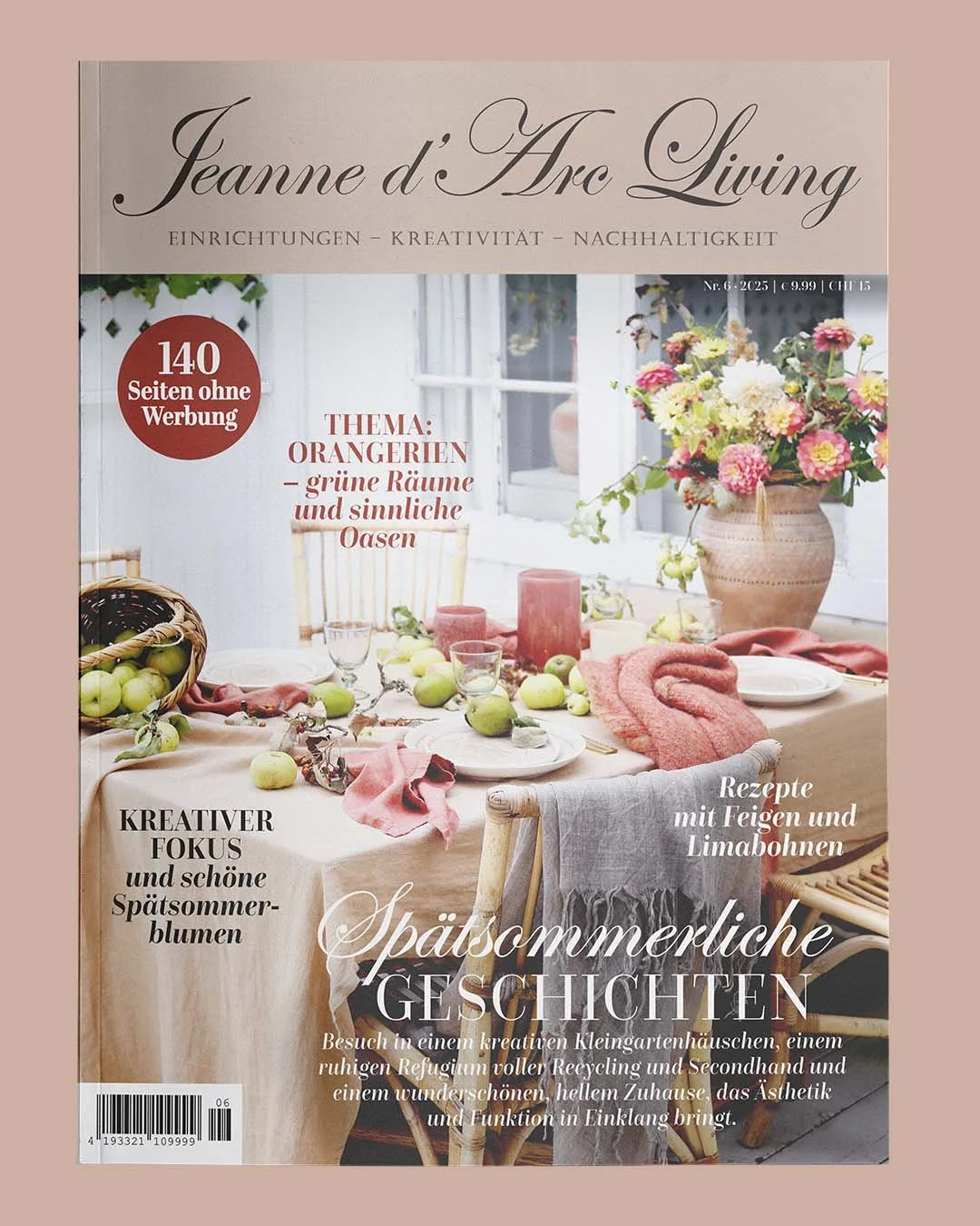 Forside af magasin med et bord dekoreret med grønne æbler, lysestager, servietter og blomster i en stor vase, omgivet af vinduer og naturligt lys.