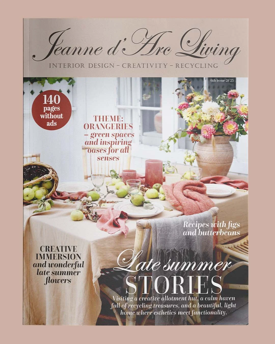 Forside af bladet Jeanne d’Arc Living med et billeder af et spisebord dækket med grønne æbler, blomster og krydderurter, omgivet af store vinduer, med rosa og lysegrønne indretningselementer.