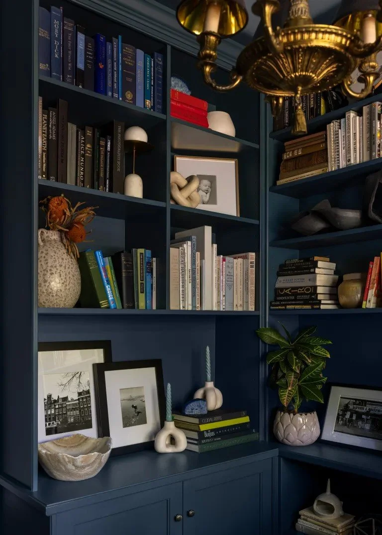A classic Tudor Revival home in Tonawanda thoughtfully updated for a growing family through layered artwork, custom built-ins, rich color, family-friendly furniture, and a considered mix of traditional and modern design.