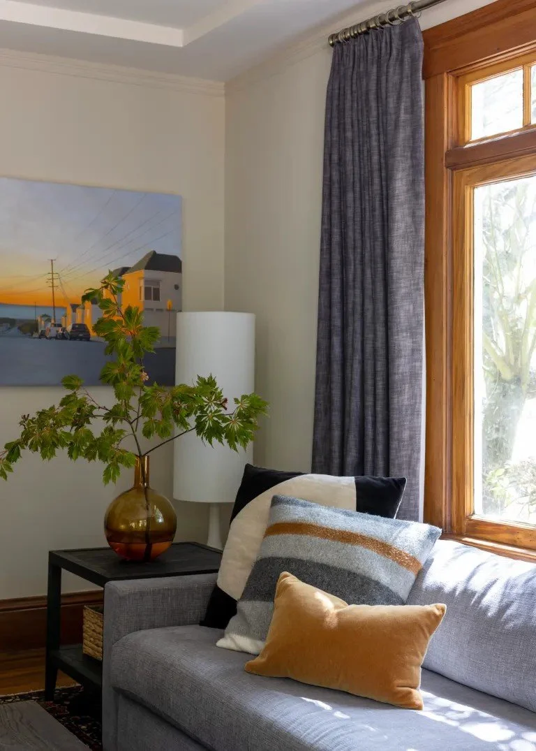 A classic Tudor Revival home in Tonawanda thoughtfully updated for a growing family through layered artwork, custom built-ins, rich color, family-friendly furniture, and a considered mix of traditional and modern design.