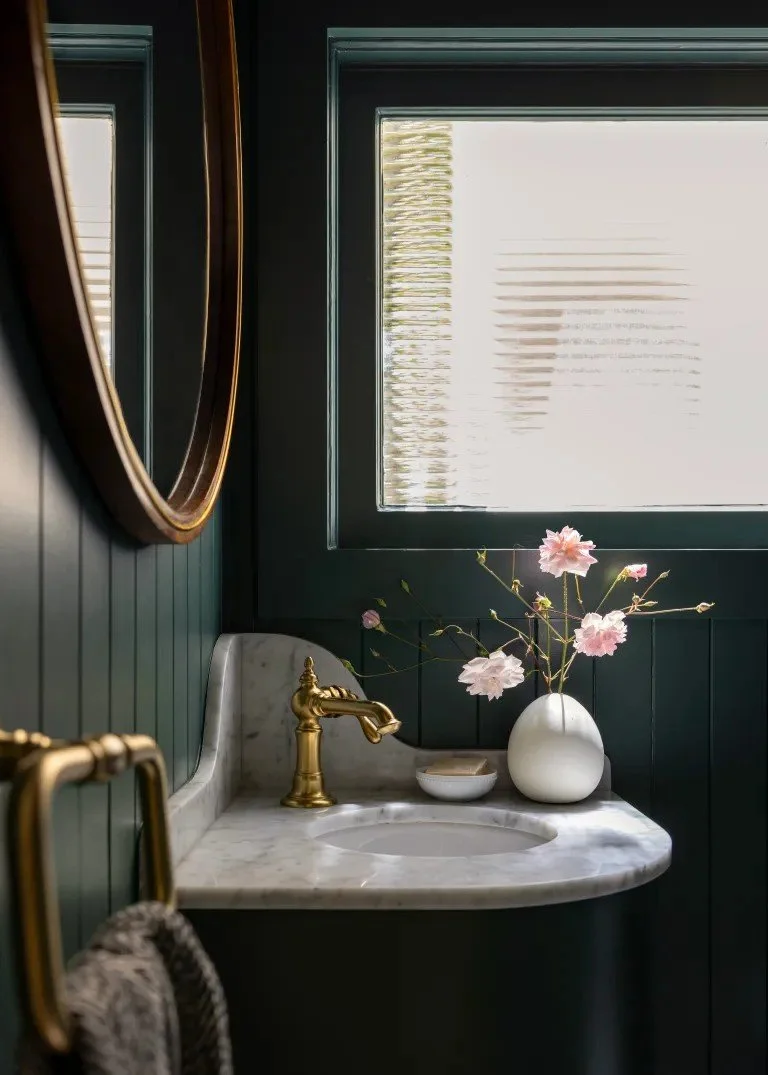 A classic Tudor Revival home in Tonawanda thoughtfully updated for a growing family through layered artwork, custom built-ins, rich color, family-friendly furniture, and a considered mix of traditional and modern design.