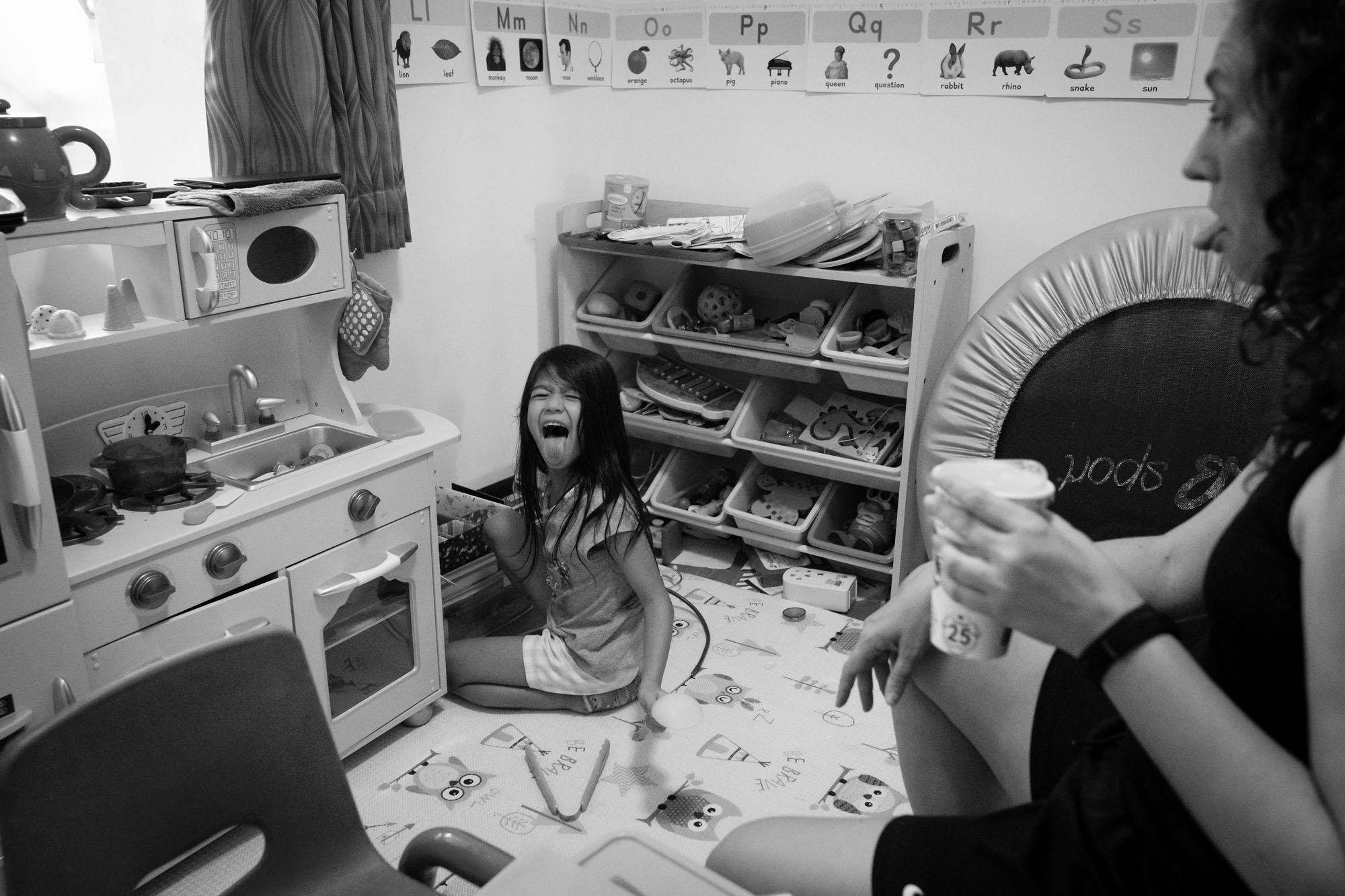 A mother and daughter play and stick out their tongues at one another in their home in Taipei, Taiwan.