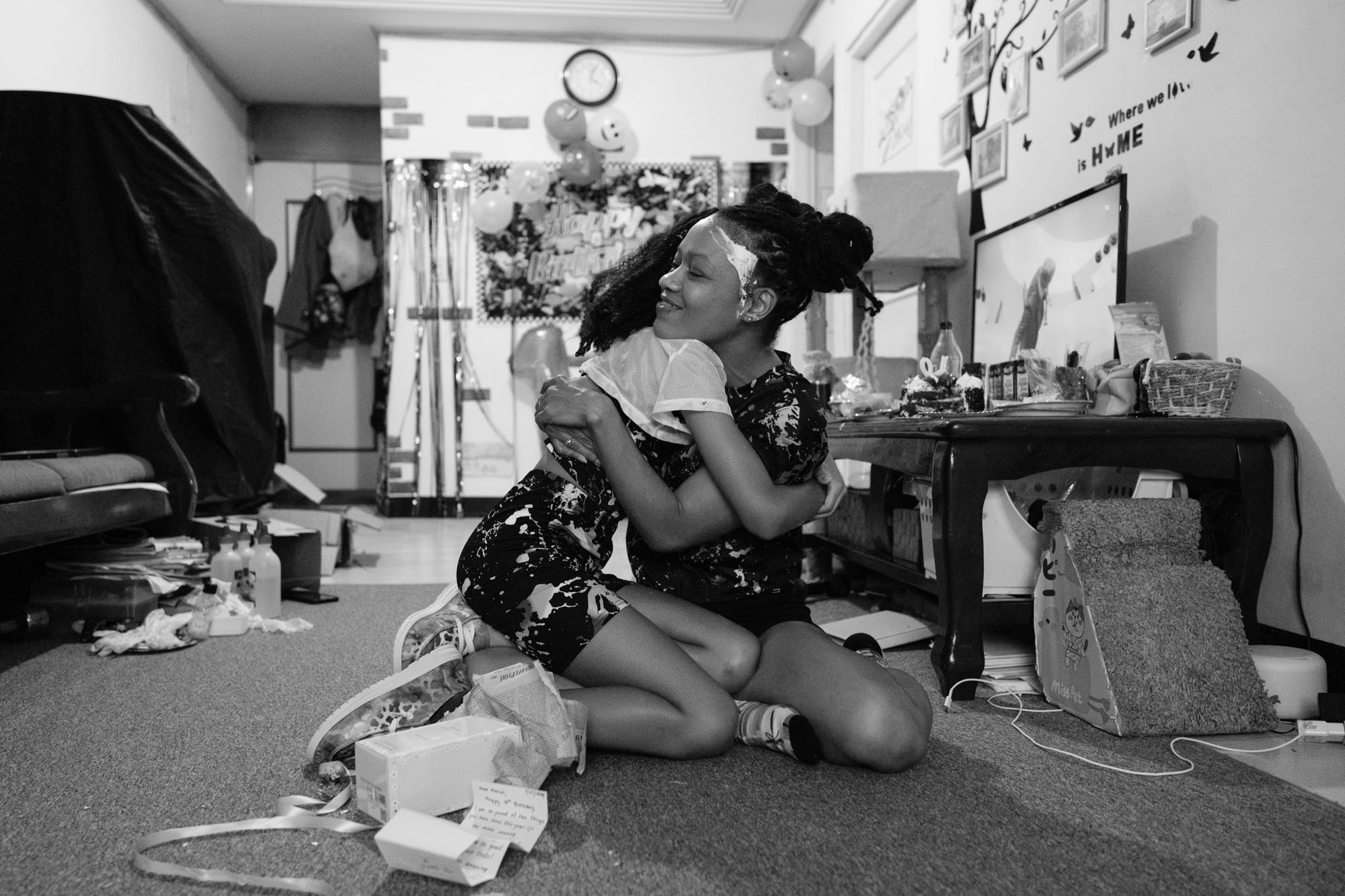 A mother and daughter tenderly embrace after a birthday gift is opened; photographed by documentary family photographer Cahleen Hudson.