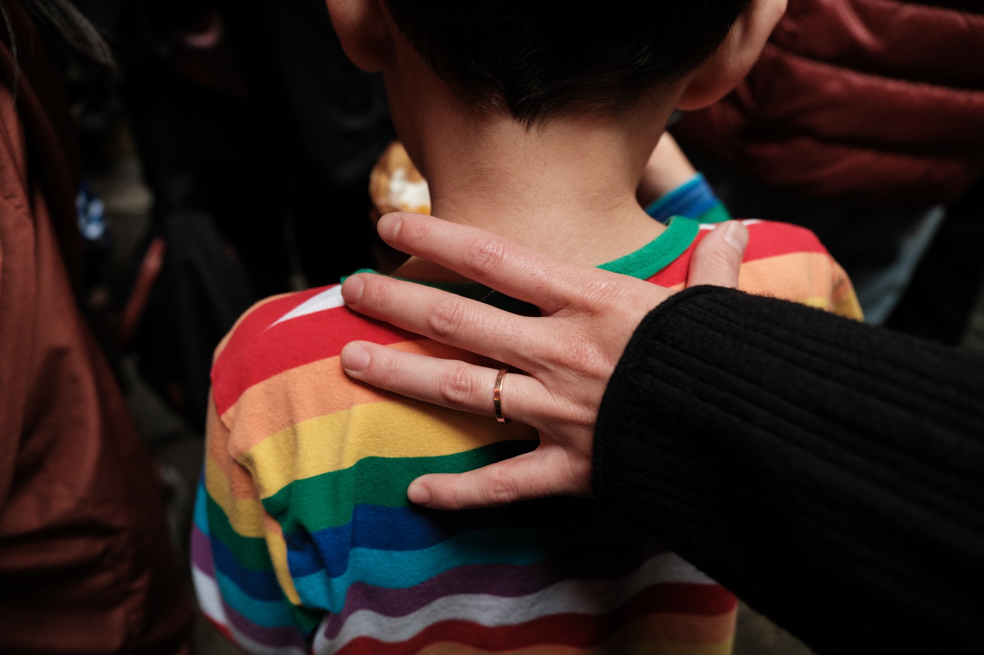 A mom's hand is on her son's shoulder as she guides him through the crowd at Jiufen Old Street in Taiwan; photographed by family photographer Cahleen Hudson.