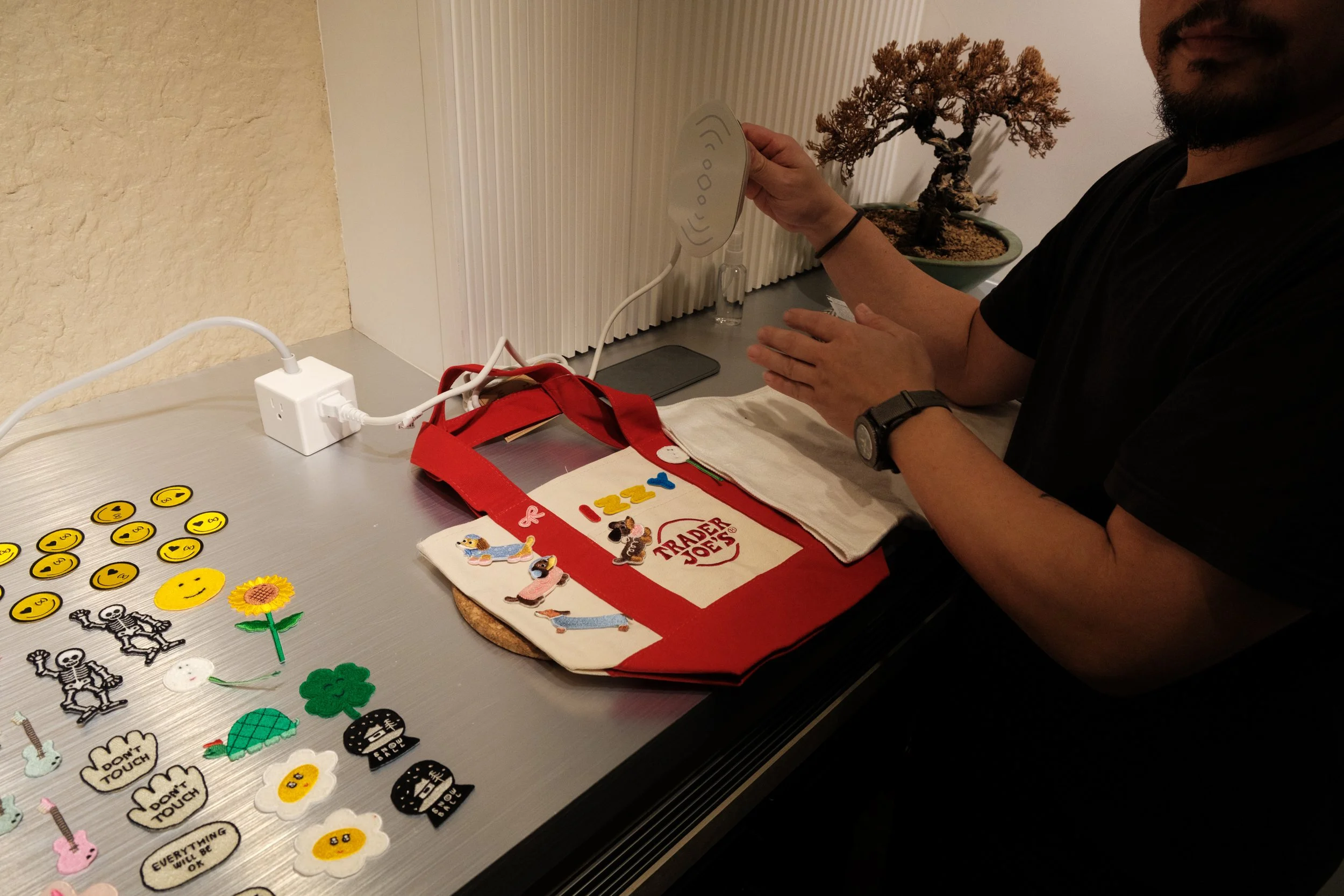 A man irons patches onto a Trader Joe's tote bag at his daughter's 9th birthday paty at MRKT5 in Taipei.